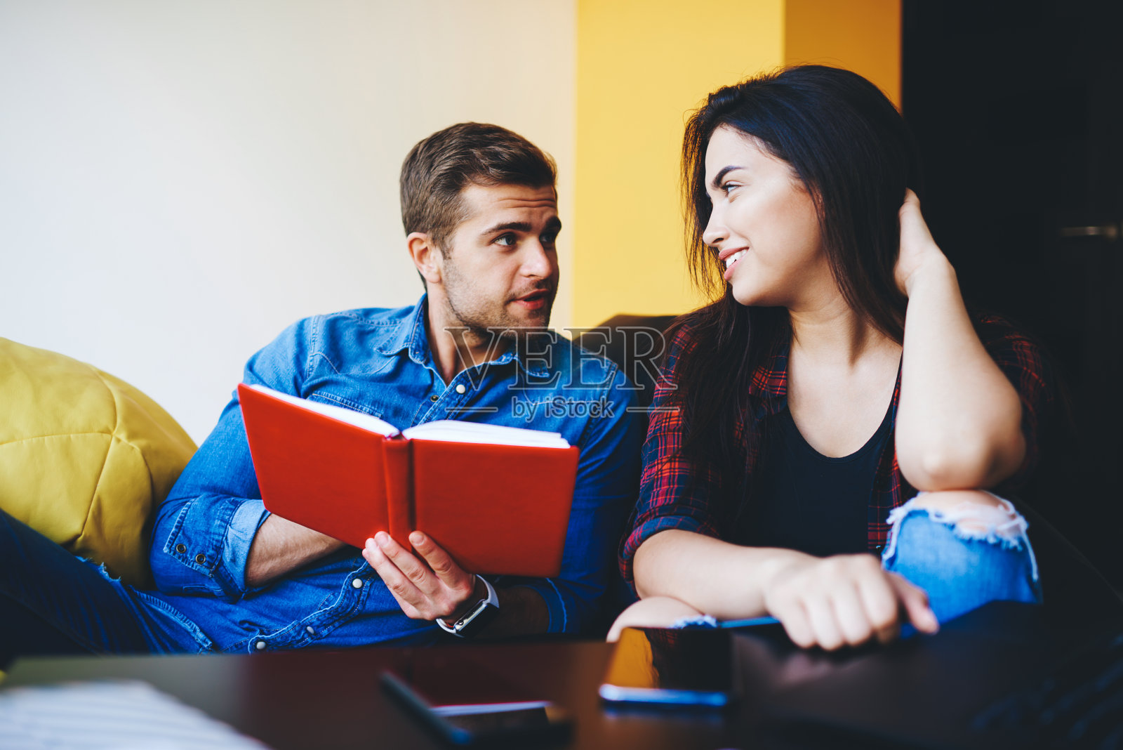 在商学院，白人男女学生讨论关于家庭作业和共同项目学习的想法，男人拿着写有信息的记事本和女同事在工作上合作照片摄影图片