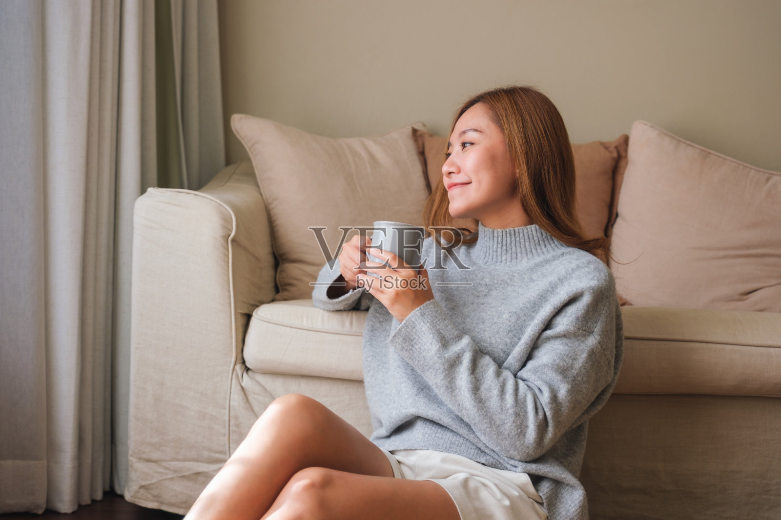一个美丽的年轻亚洲女子的肖像图像，在家里放松时喝热咖啡照片摄影图片