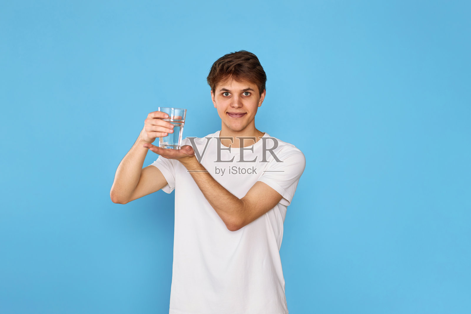 年轻英俊的男人拿着一杯水照片摄影图片