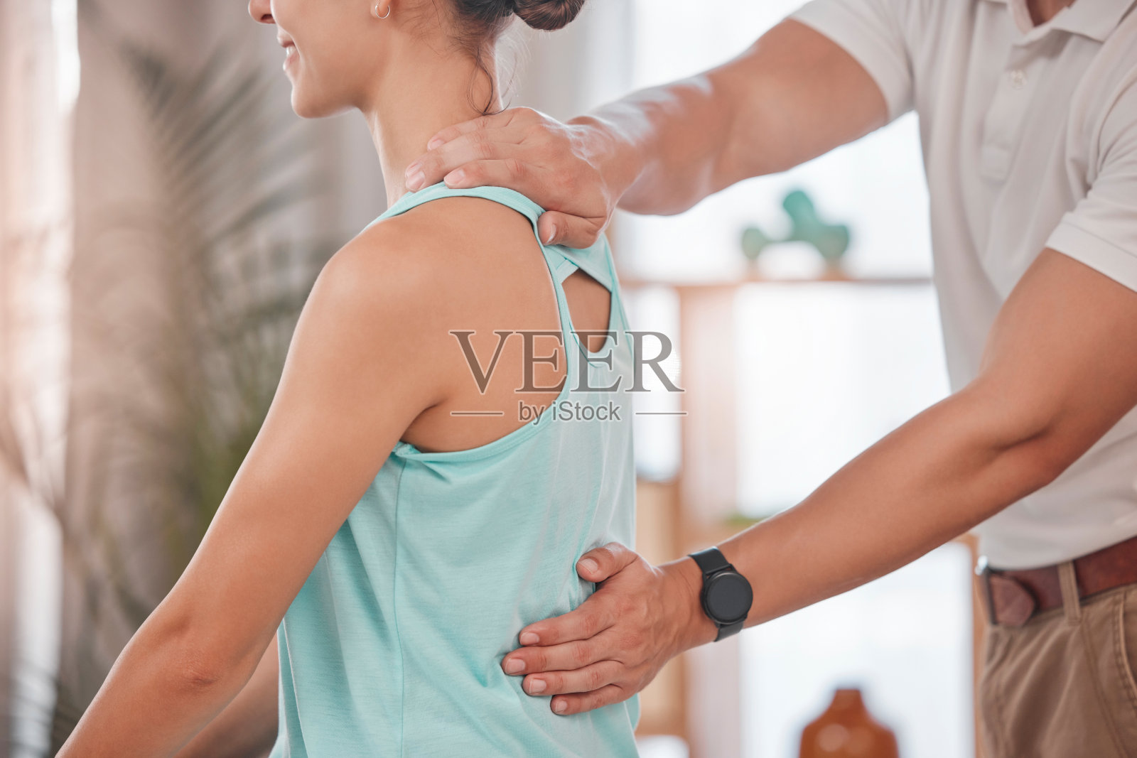 脊椎按摩师，咨询和妇女在物理治疗她的背部疼痛，肌肉压力和身体表现。物理治疗，支持和运动员与物理治疗师帮助康复照片摄影图片