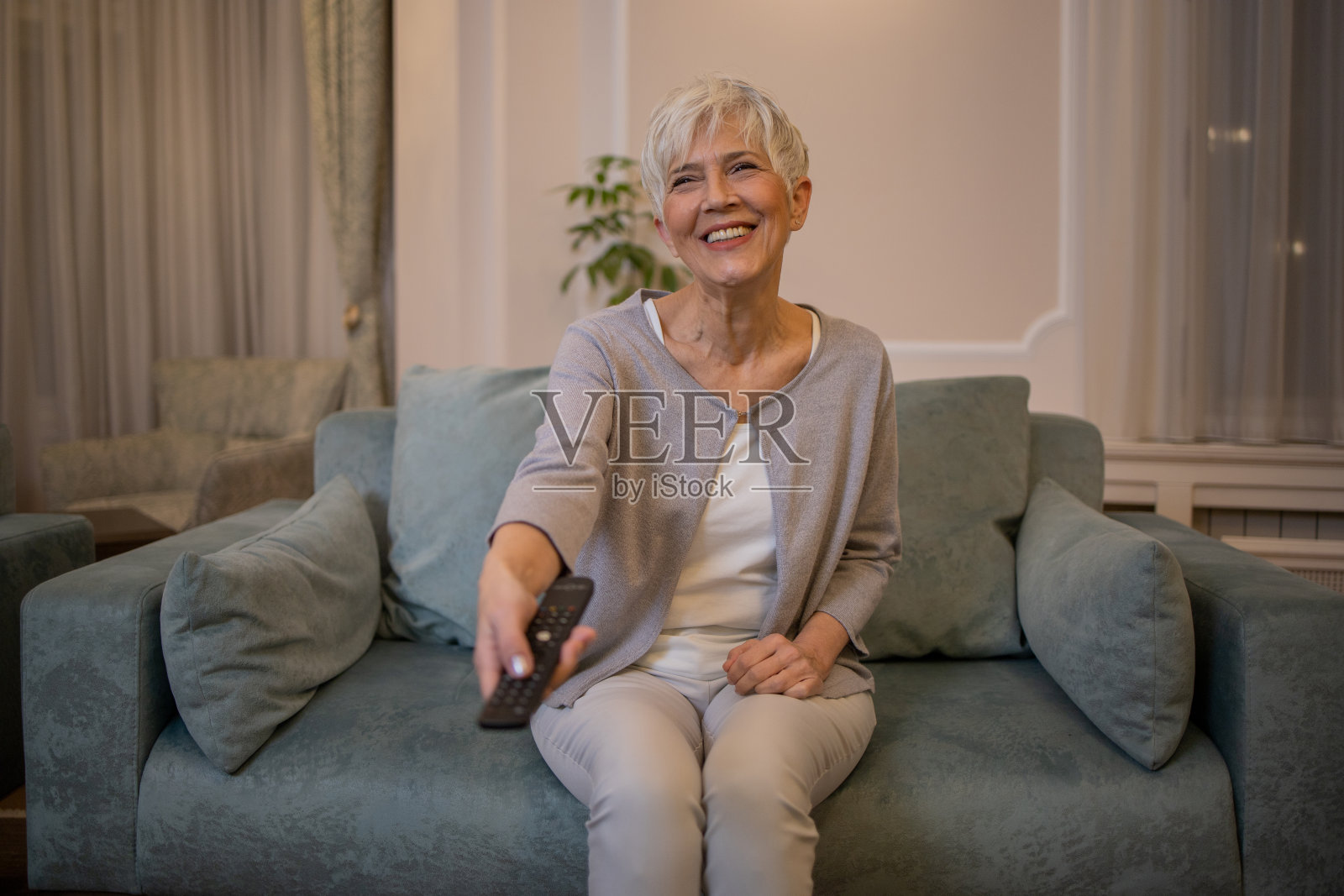 女人在家里享受她最喜欢的电视节目照片摄影图片