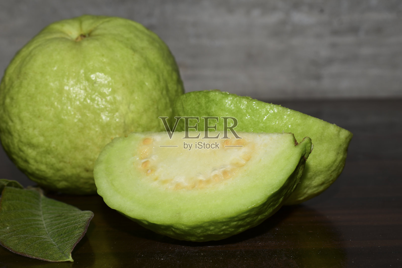 新鲜的番石榴和绿叶放在木桌上照片摄影图片