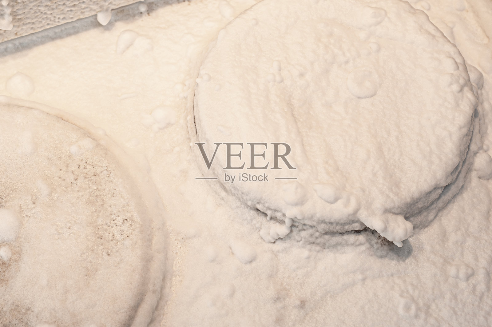 厨房的炉子用白色泡沫洗涤剂处理过，不会有卷曲的污垢照片摄影图片