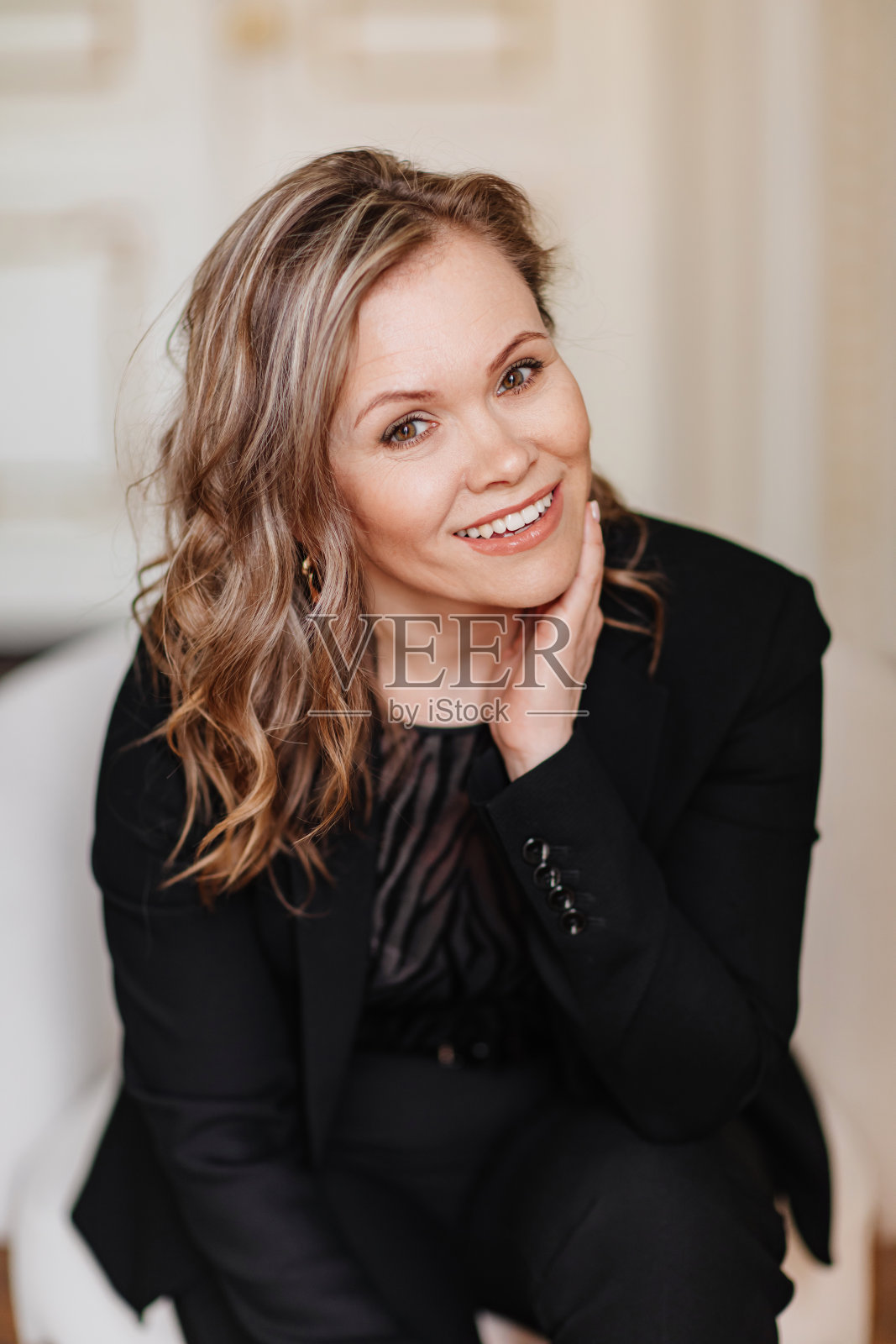 一个穿着黑色西装的迷人、有女人味、自信的女人。照片摄影图片