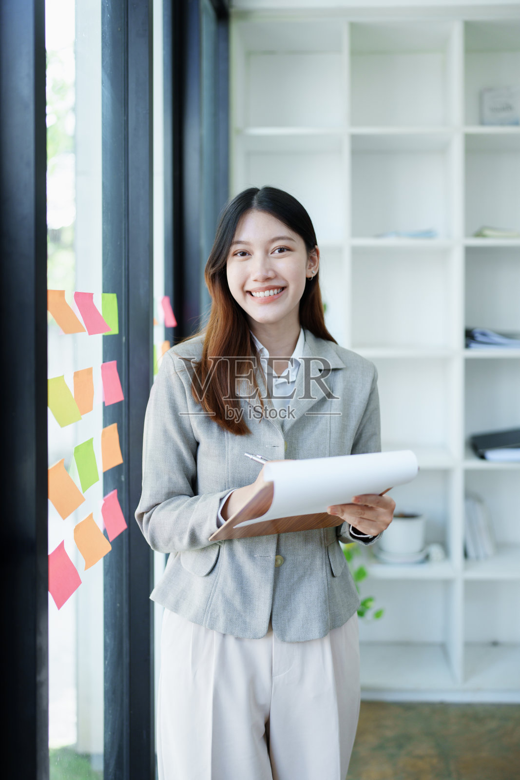 一个深思熟虑的亚洲女商人的肖像，看着财务报表，并在办公室制定营销计划照片摄影图片