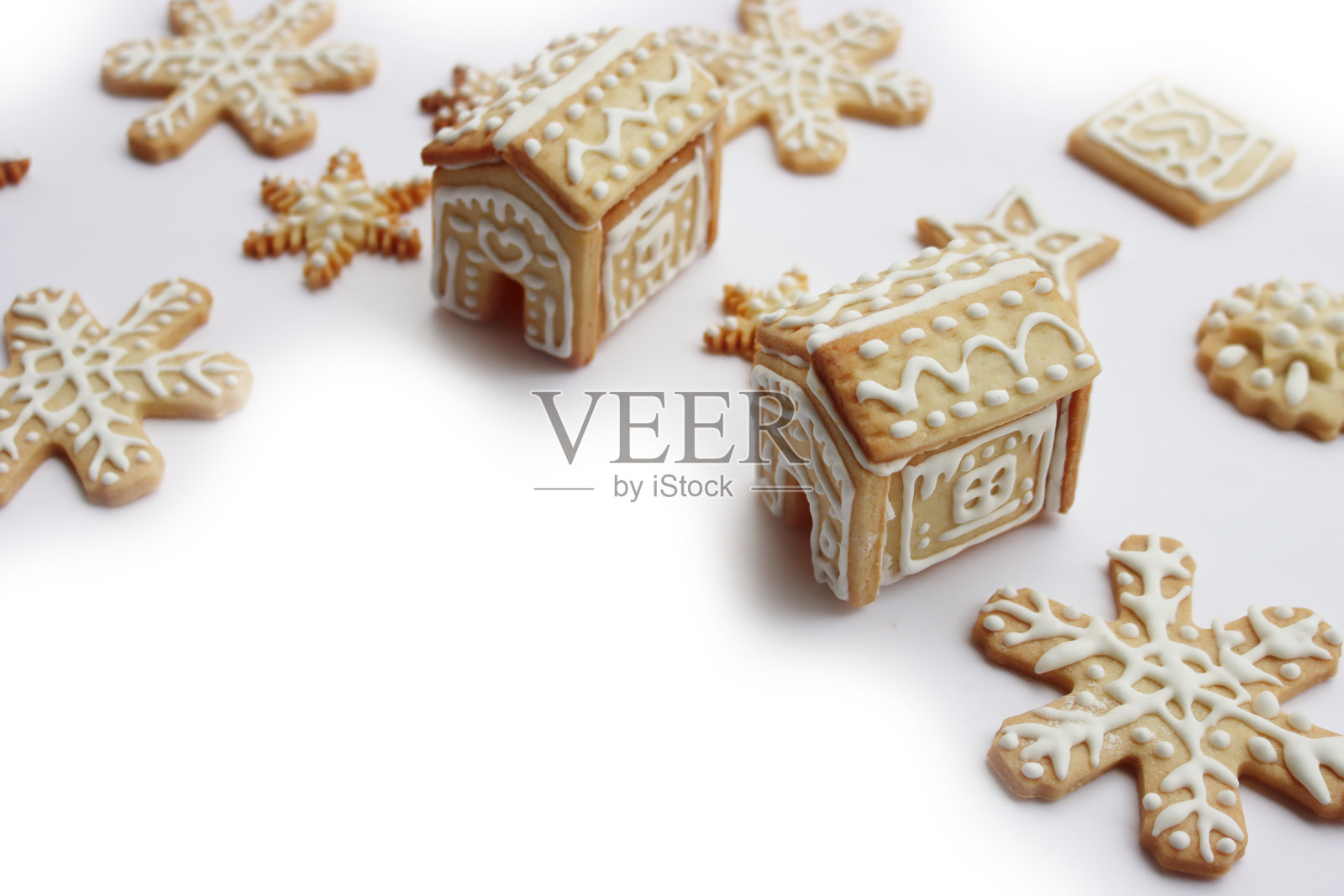 小姜饼屋与姜饼饼干形状的星星和雪花在白色复制空间照片摄影图片