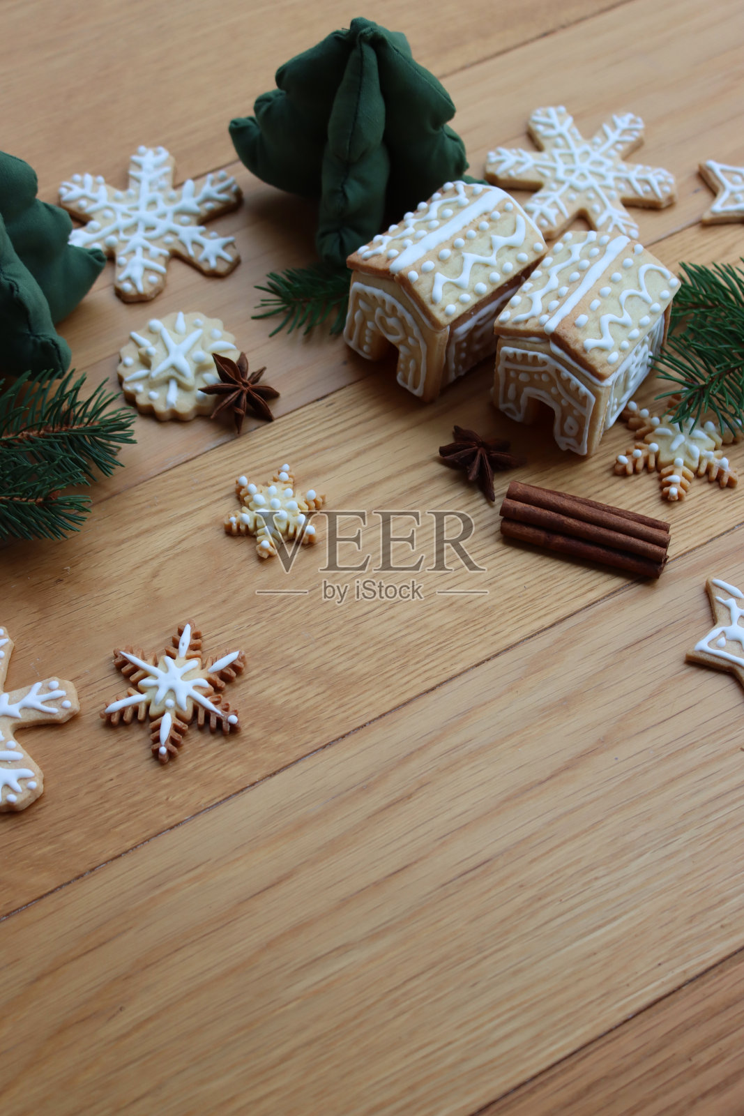 姜饼屋，木桌上放着星星和雪花形状的姜饼曲奇，还有松枝、肉桂和八角茴香香料照片摄影图片