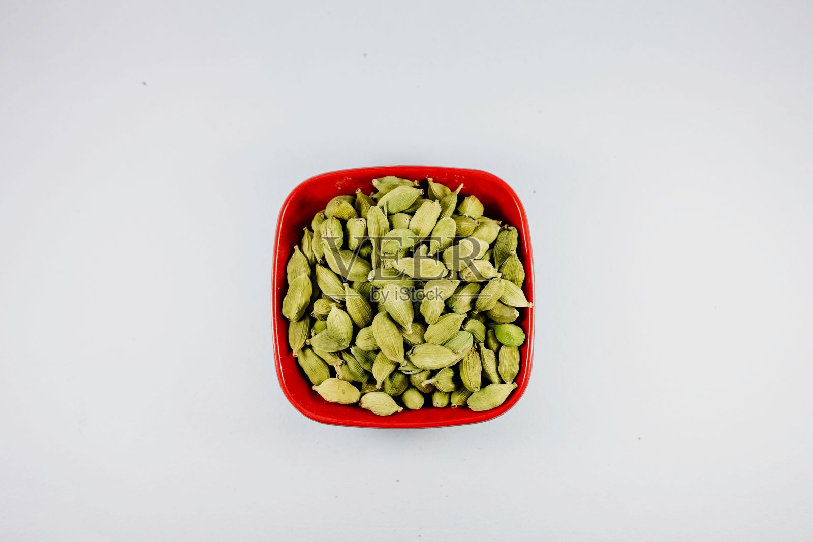 一堆绿色豆蔻在碗孤立的白色背景照片摄影图片