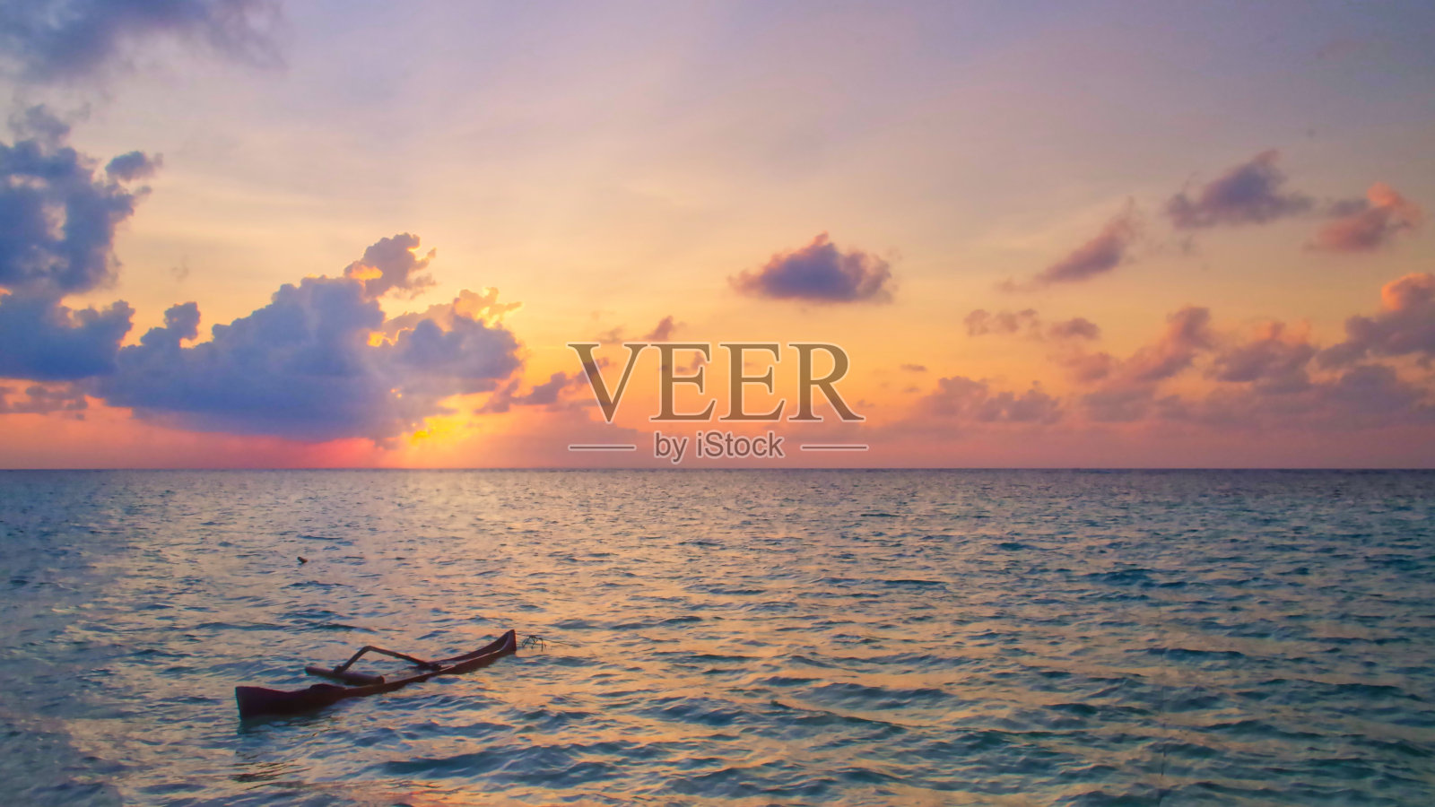 平静的海面上神奇的日落，一只只小船在无边无际的海洋中航行照片摄影图片