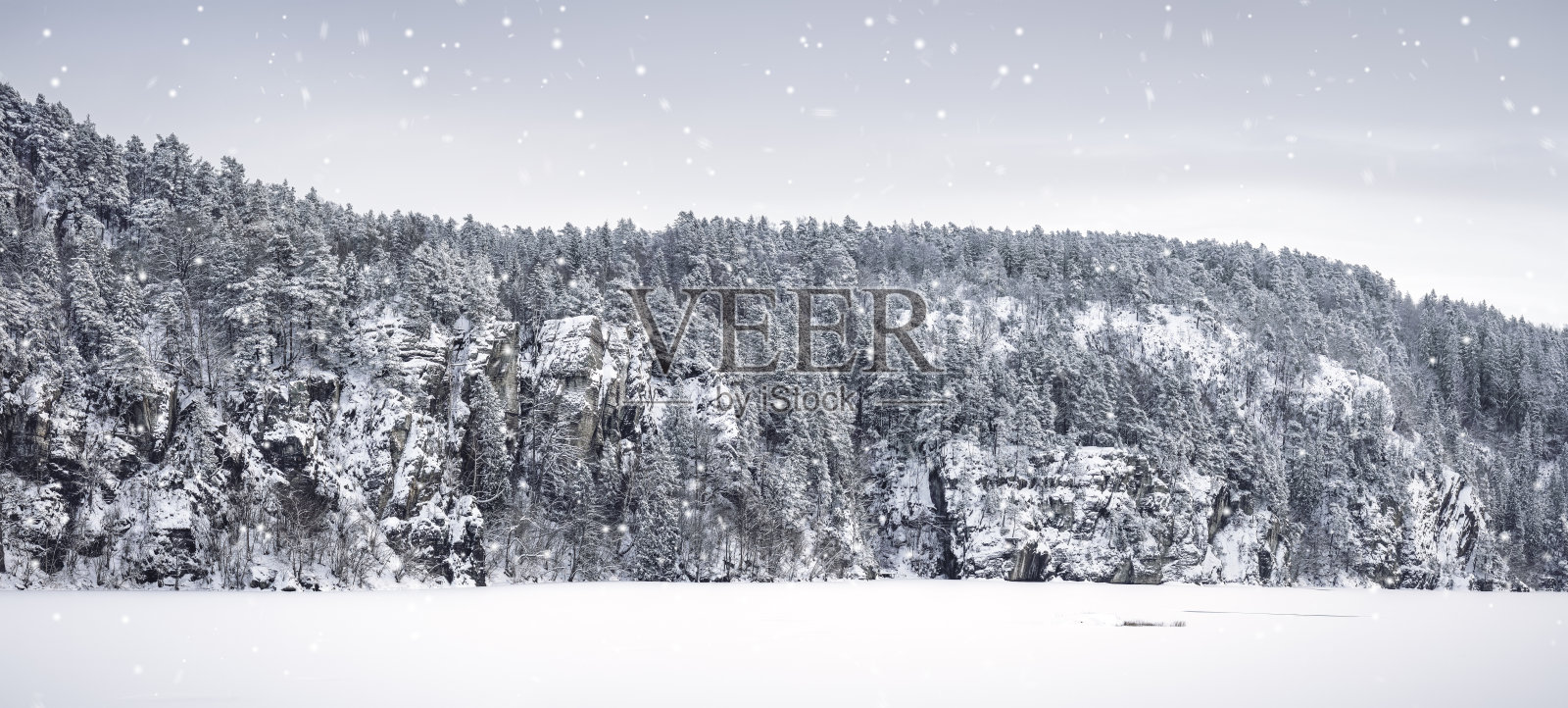 高分辨率冬季景观，有冰雪覆盖的森林和岩石，阴天。照片摄影图片