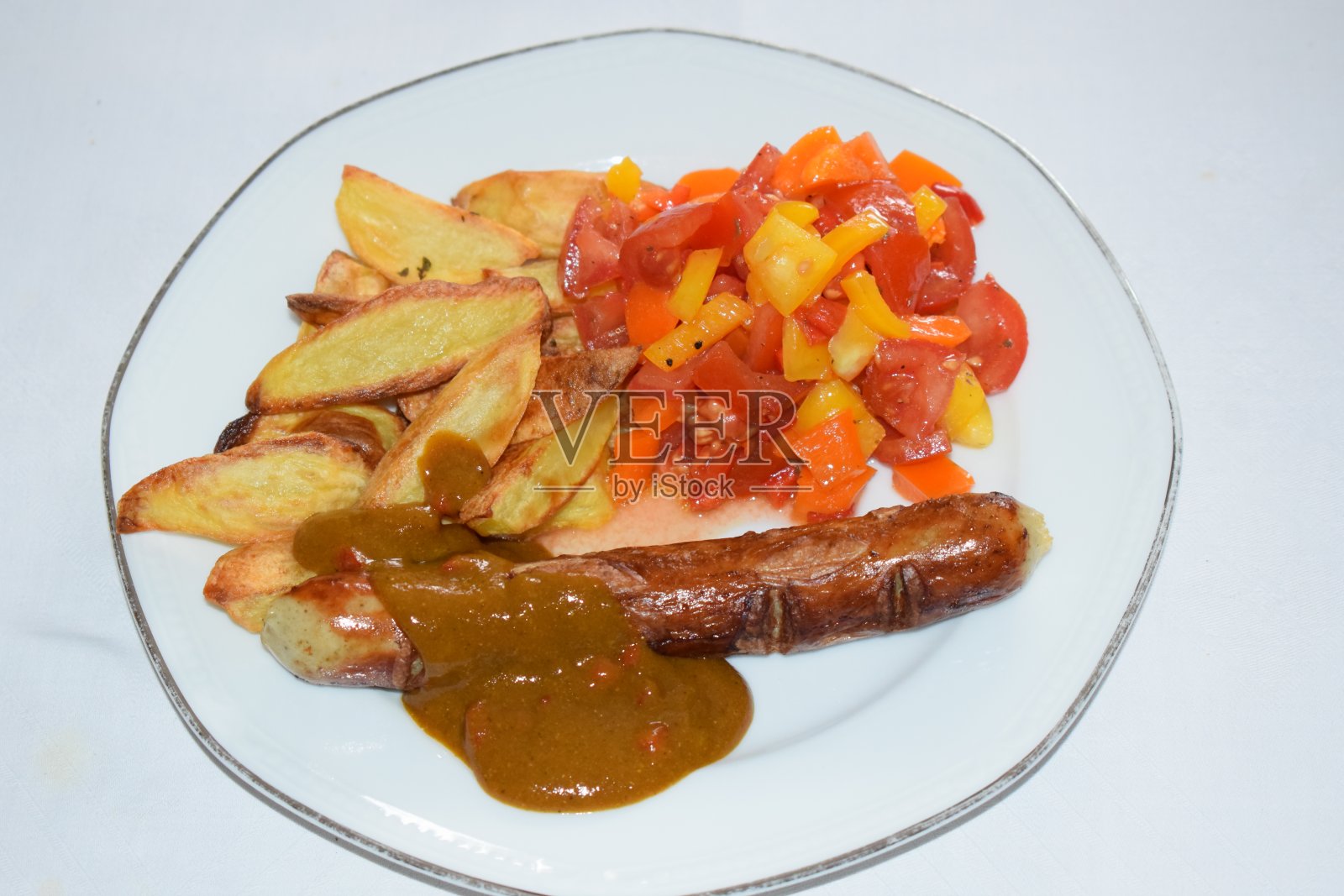 咖喱香肠、薯条和沙拉照片摄影图片