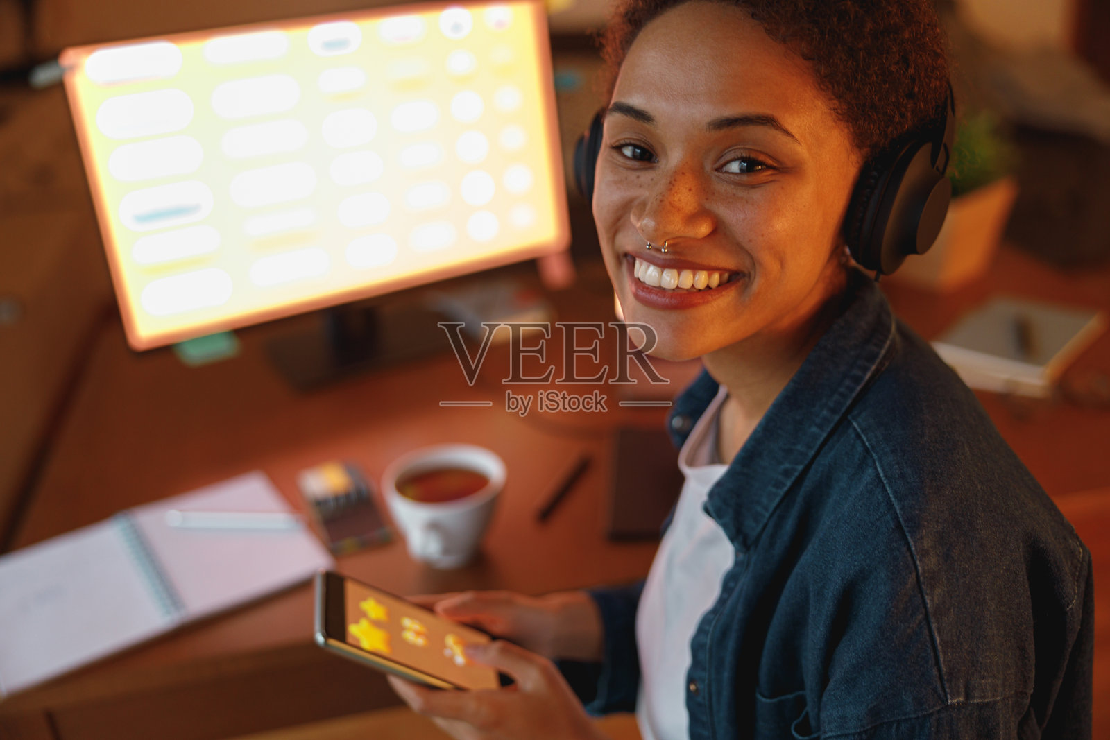 美国黑人女性平面设计师喝茶在休息期间在家里办公室。自由的概念照片摄影图片