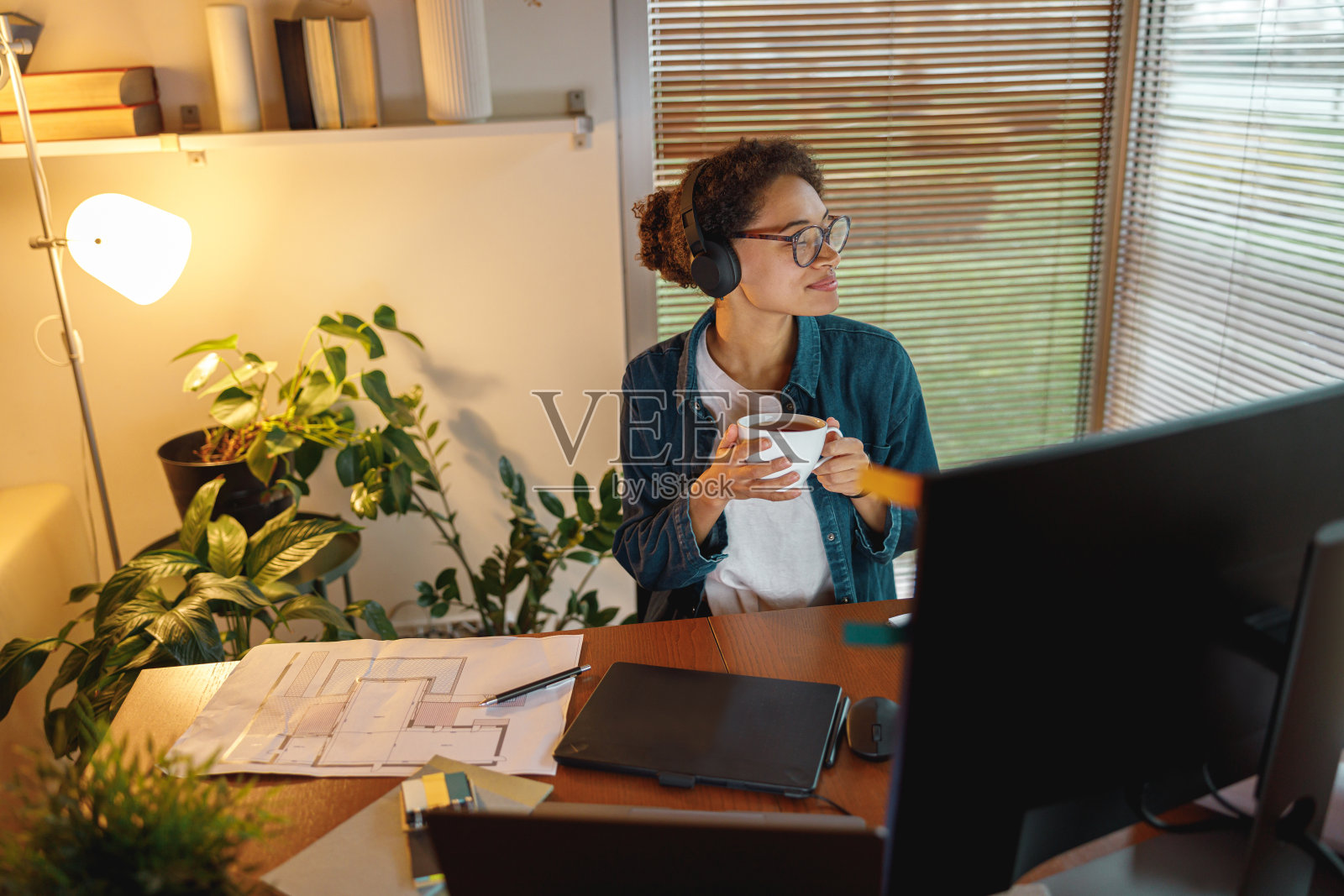 非裔美国女性室内设计师喝茶在休息期间在家里的办公室。自由的概念照片摄影图片
