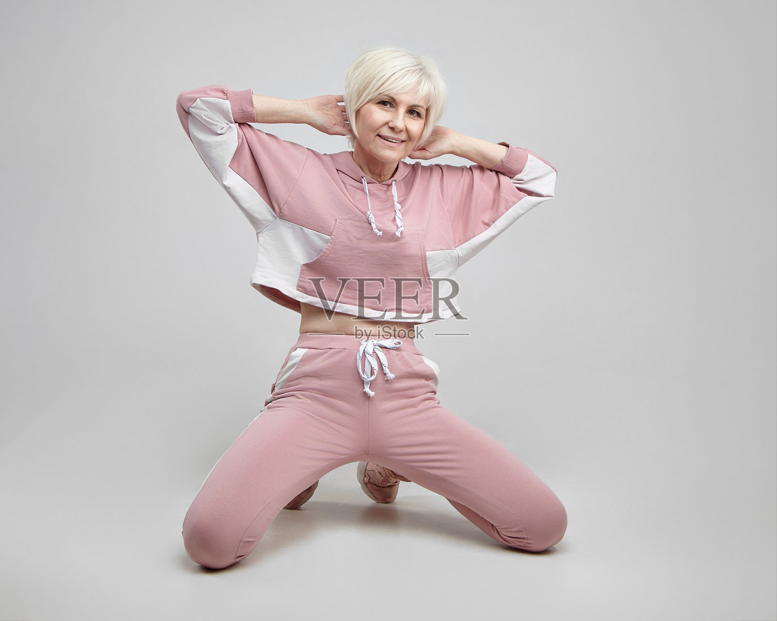 活跃的老妇人在工作室的白色背景上摆姿势。健康的概念照片摄影图片