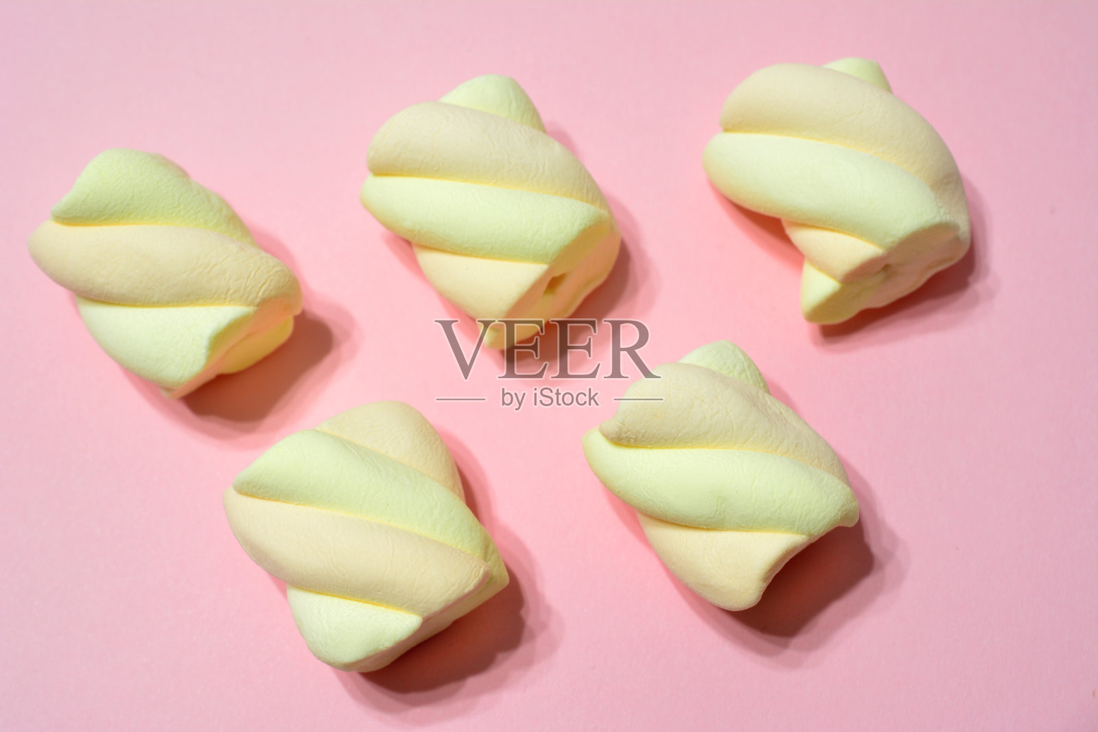 杏棉花糖在一排孤立的粉红色背景，宏照片摄影图片