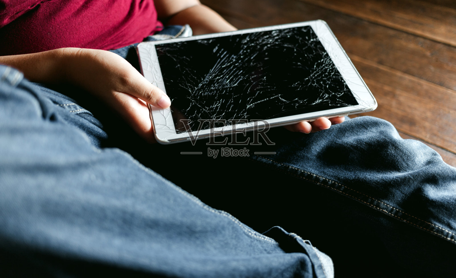 一个小亚洲男孩的肖像，孩子悲伤的脸，不开心的孩子坐着拿着坏了的平板电脑，情绪悲伤和悲伤的脸，抑郁的孩子概念照片摄影图片