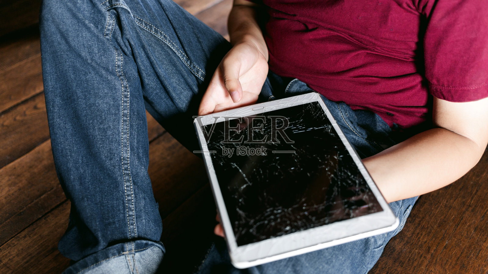 亚洲小男孩肖像，孩子悲伤的脸，不开心的孩子拿着破碎的平板电脑坐着，悲伤和悲伤的表情，沮丧的儿童概念照片摄影图片