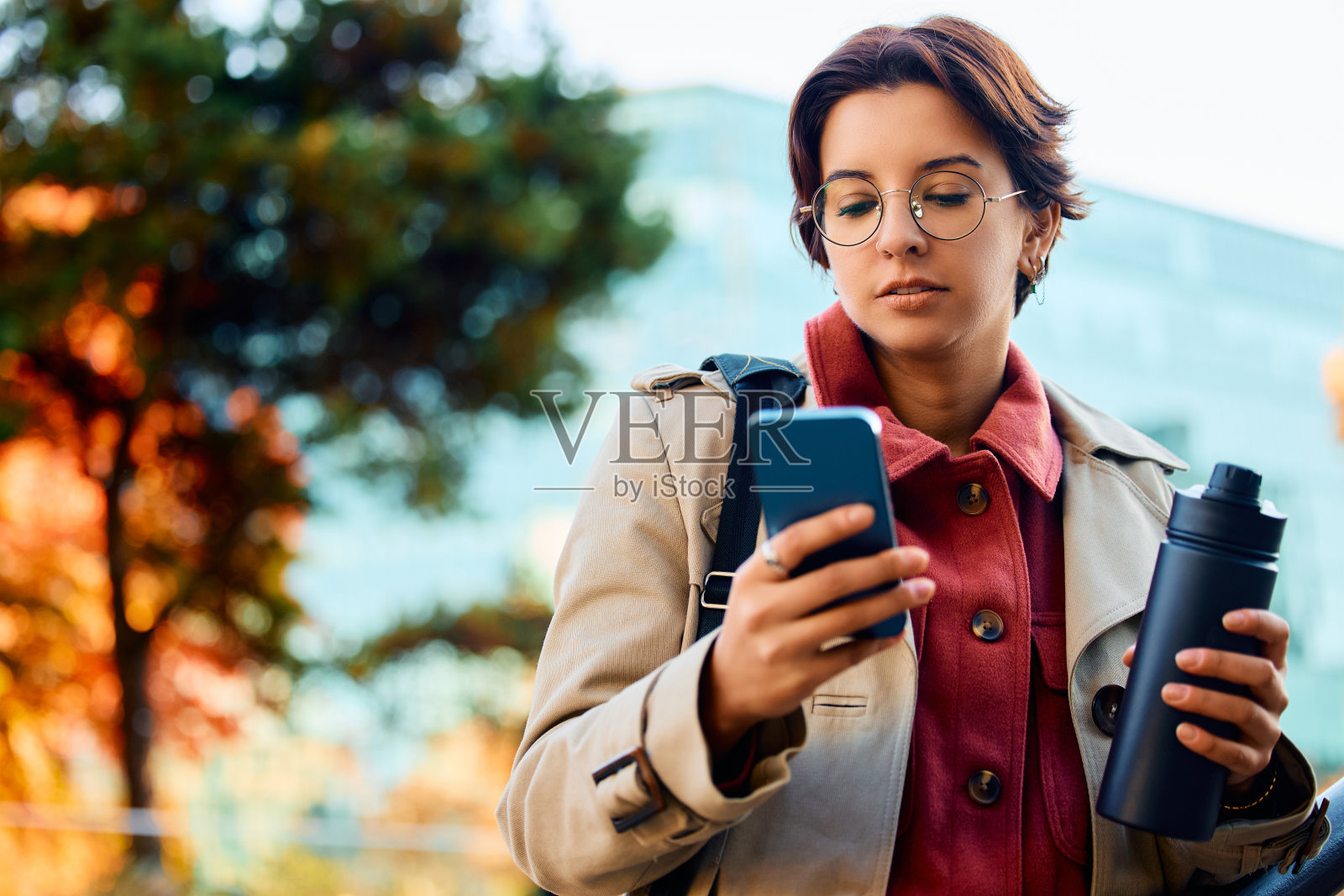 年轻的女企业家在户外发手机。照片摄影图片