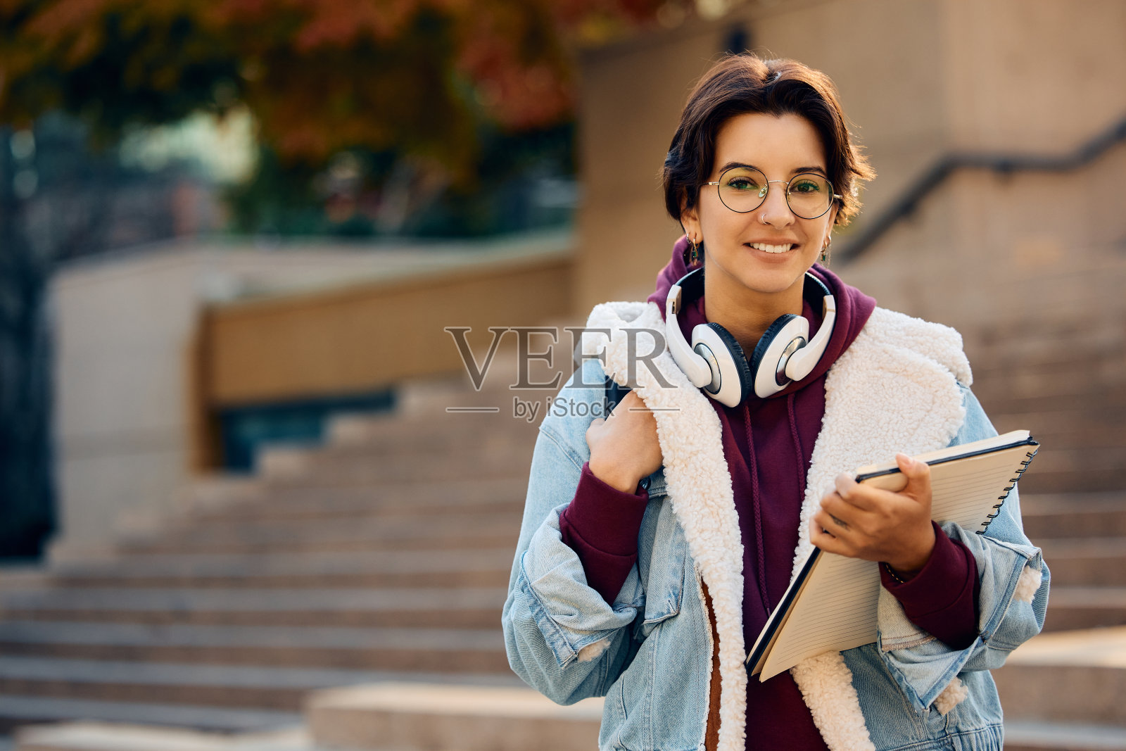 年轻女子在大学校园看着相机的肖像。照片摄影图片