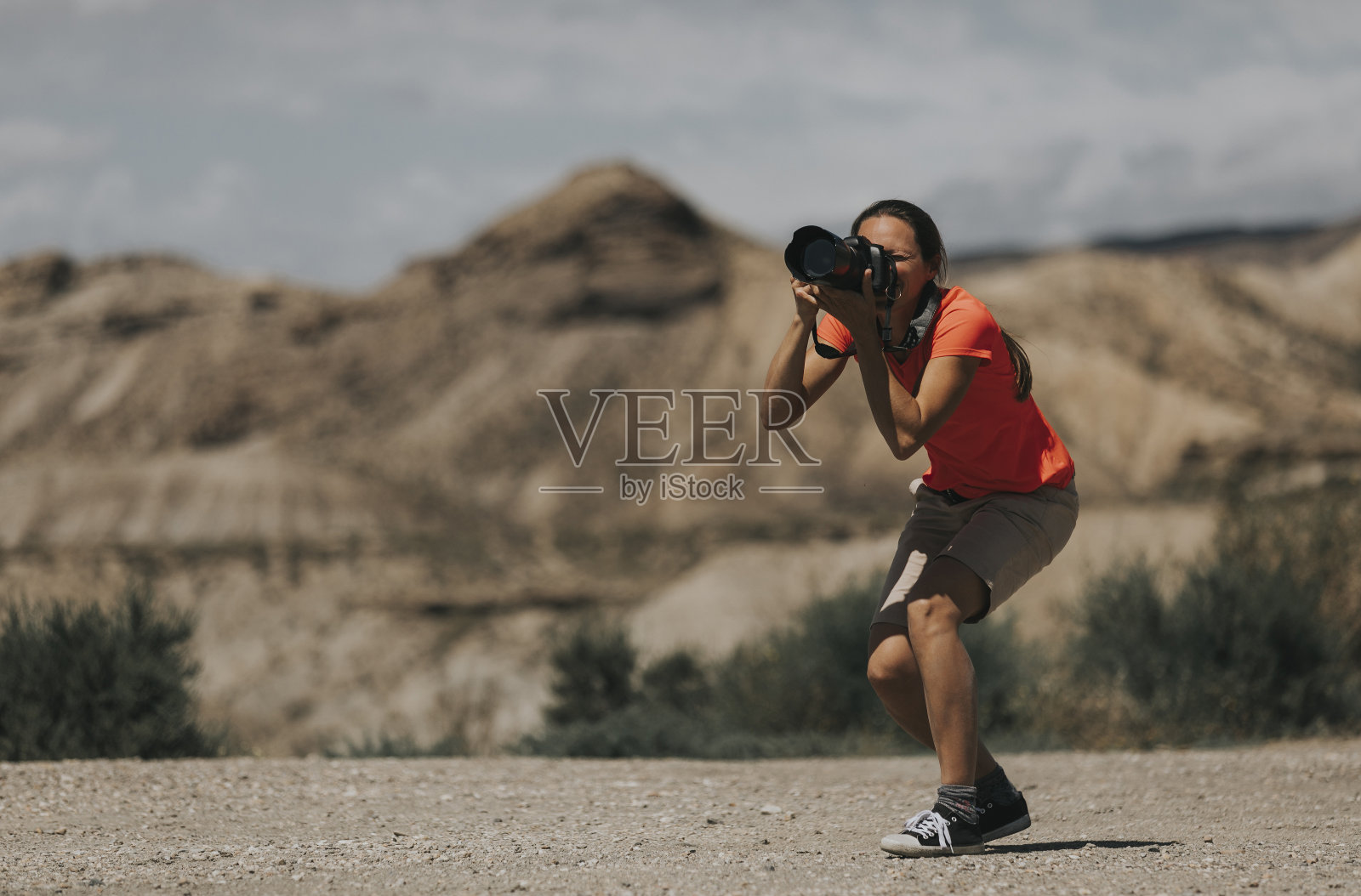 女摄影师在用她的相机拍摄。照片摄影图片