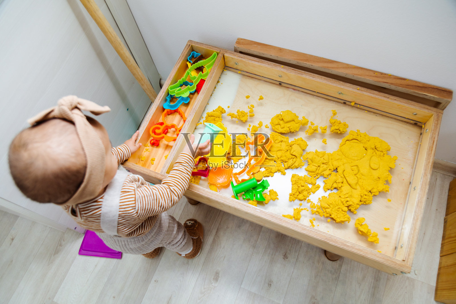 蹒跚学步的孩子用塑料形状玩动沙照片摄影图片