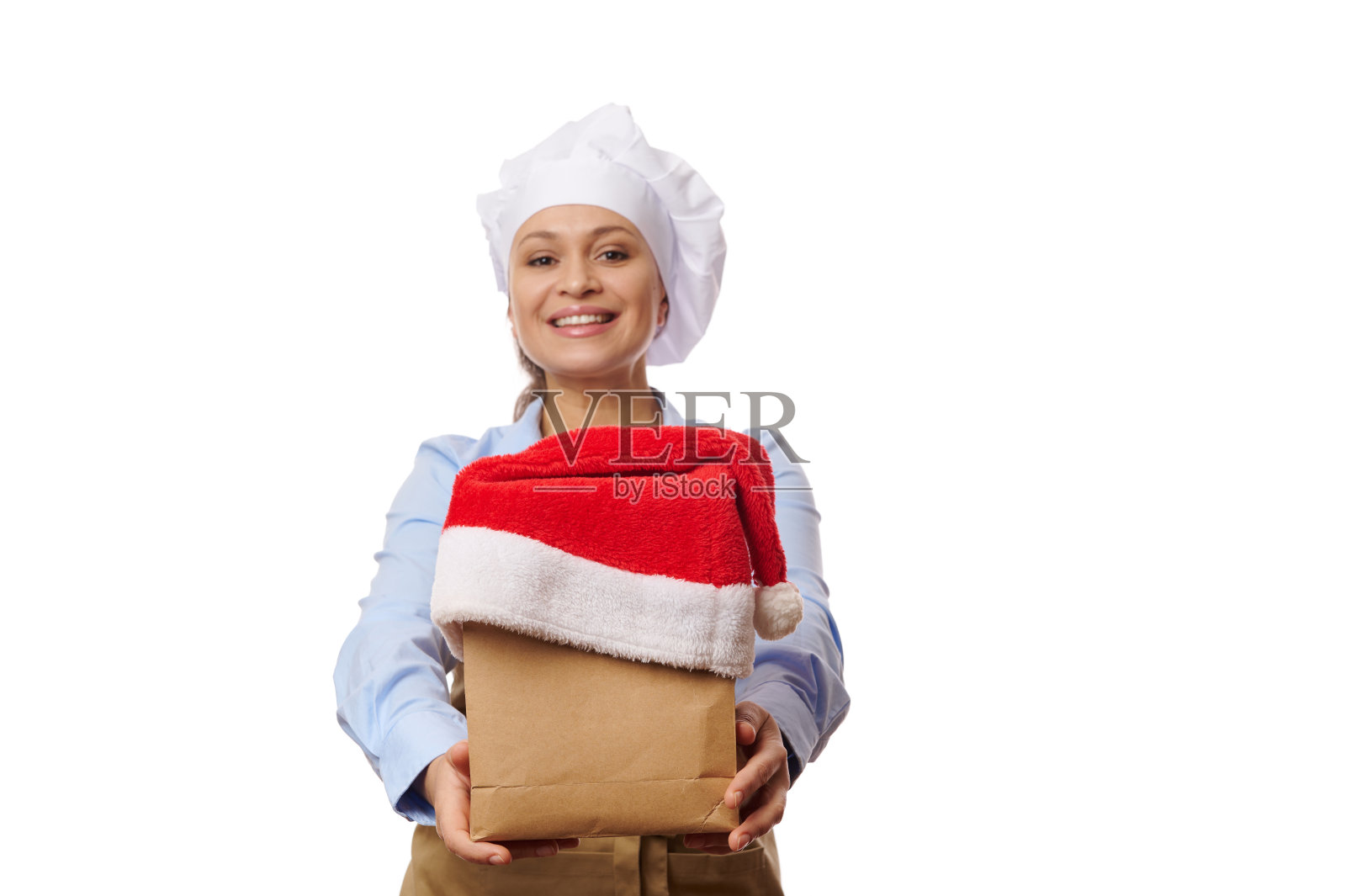 选择性地专注于纸袋上，戴着圣诞老人的帽子，手里拿着开朗的服务员。餐饮外卖概念照片摄影图片