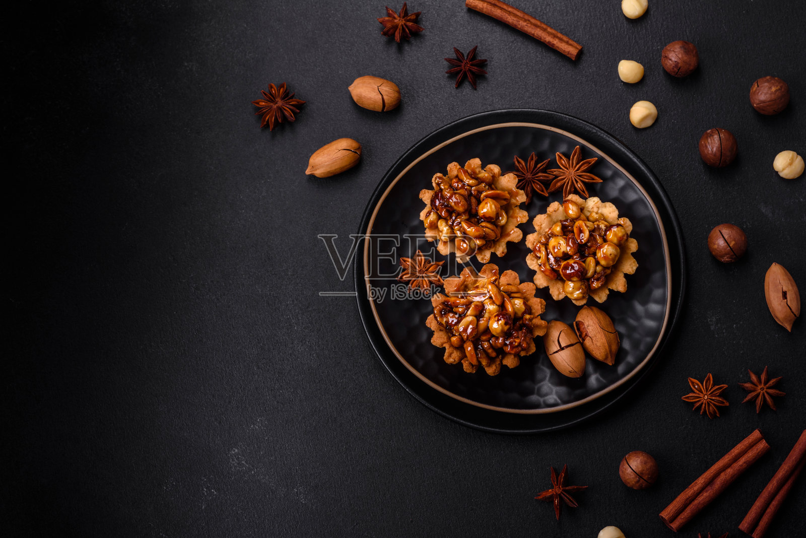 香甜可口的蛋挞配上坚果和蜂蜜，背景是深色混凝土照片摄影图片