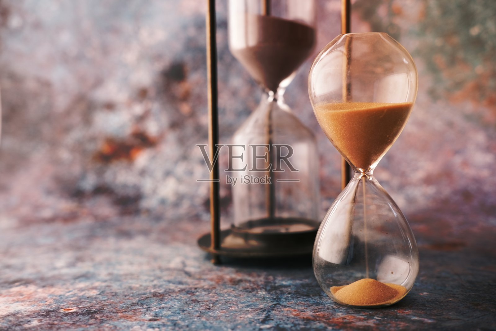 沙漏在桌子上，沙子流过沙漏的球照片摄影图片