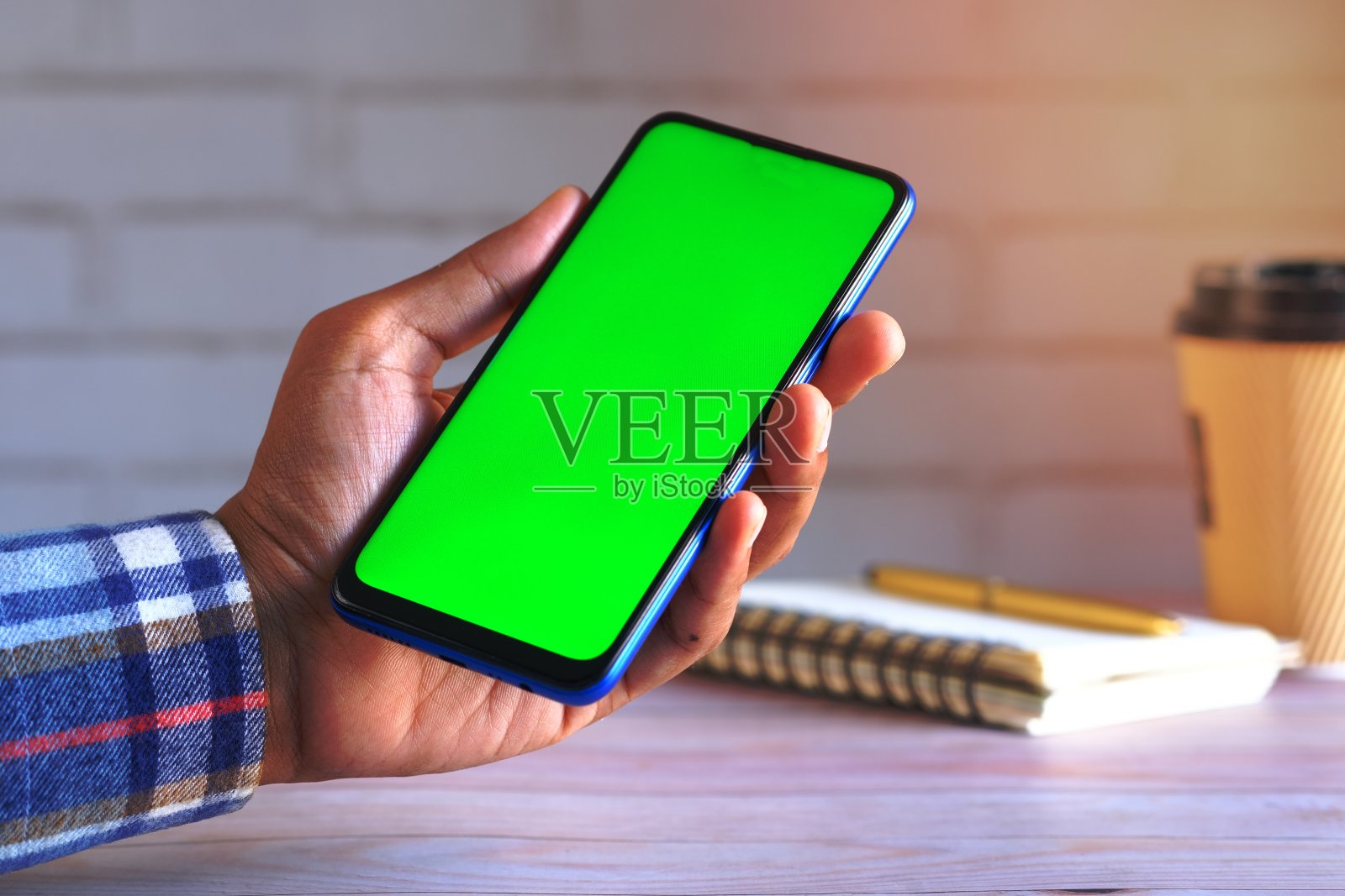 近距离的年轻人的手使用智能手机与绿色屏幕照片摄影图片