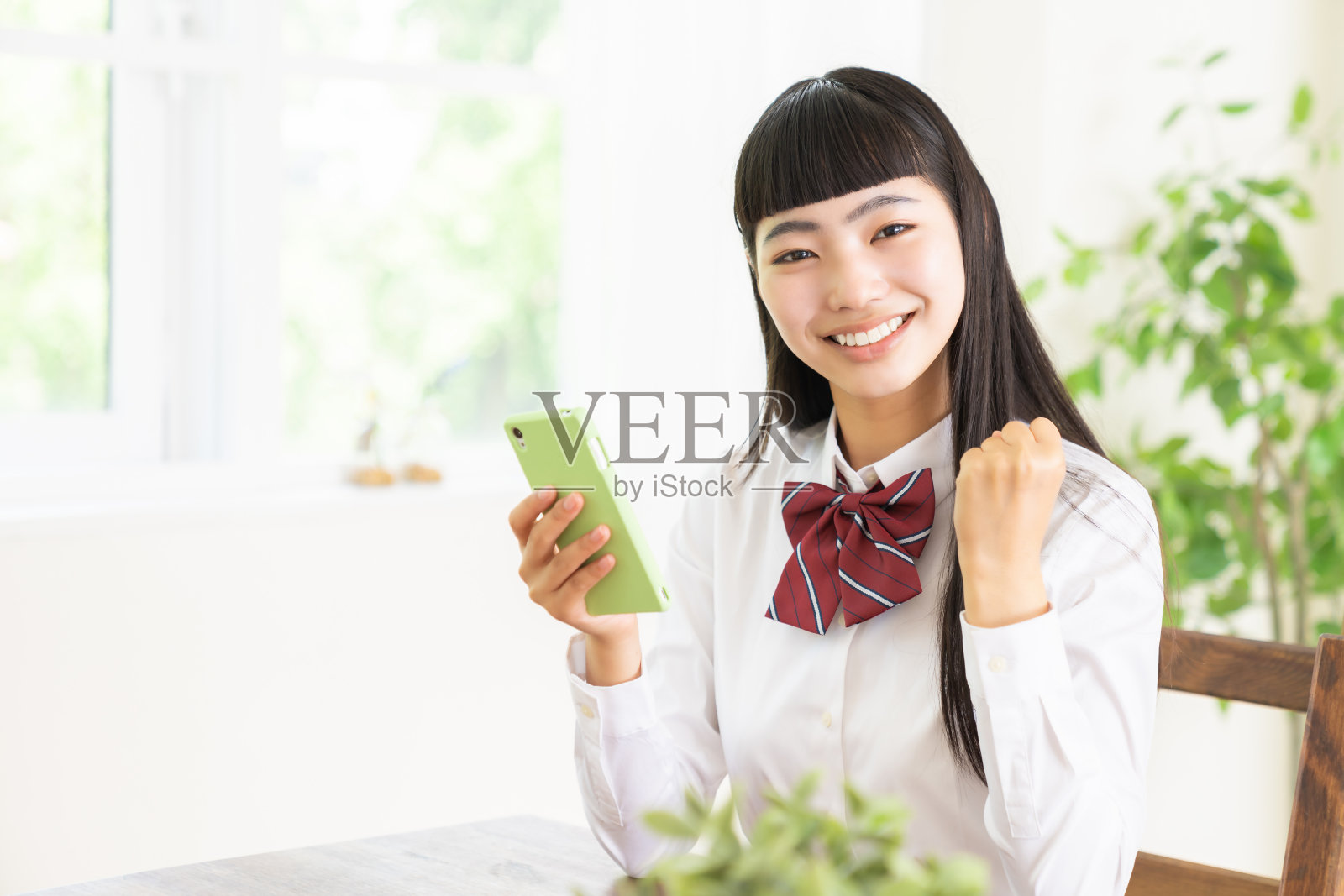 女学生使用智能手机，校服，照片摄影图片