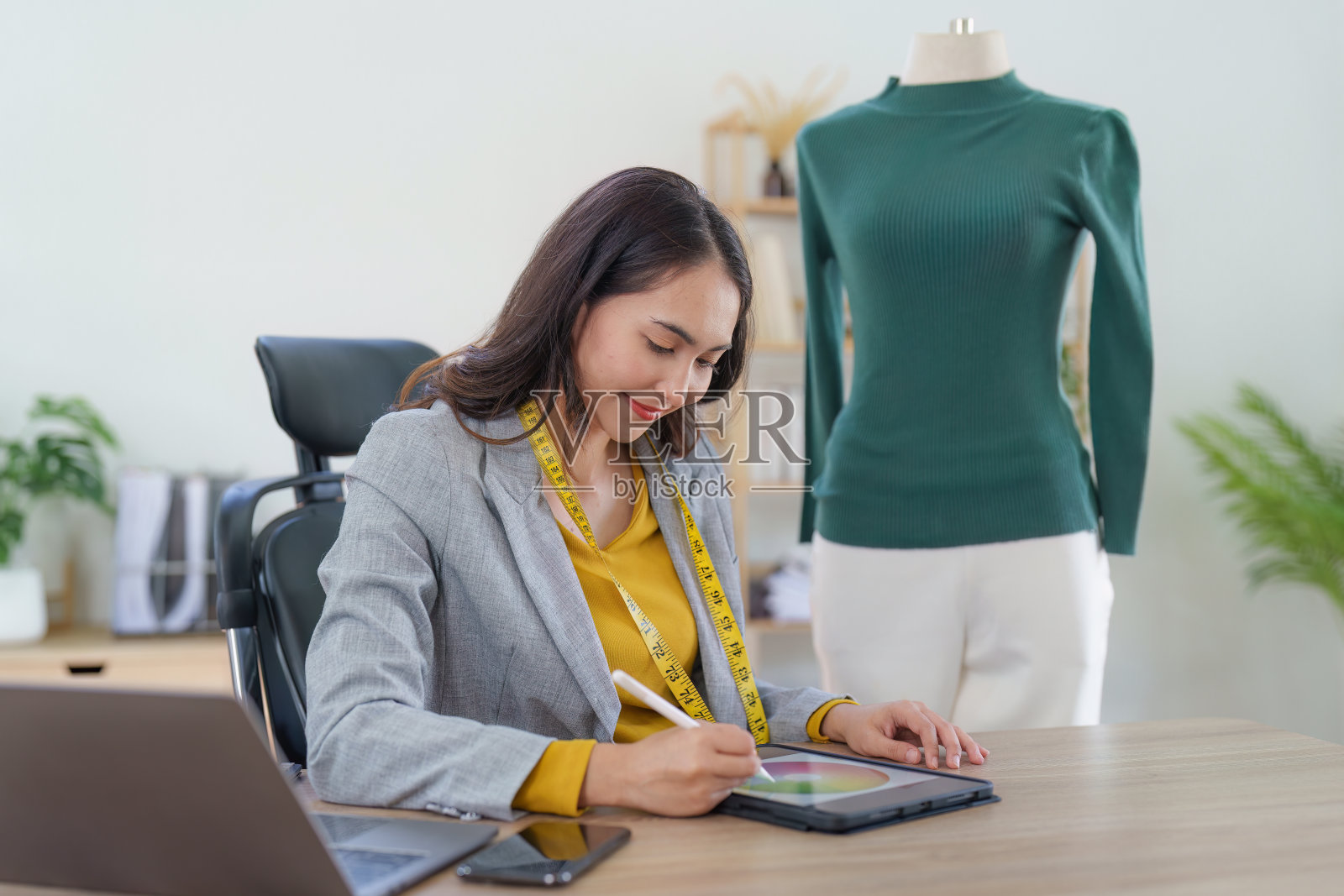 亚洲女性时装设计师布裁缝创意工作的新系列。快乐的网上商店老板准备运输订单。照片摄影图片