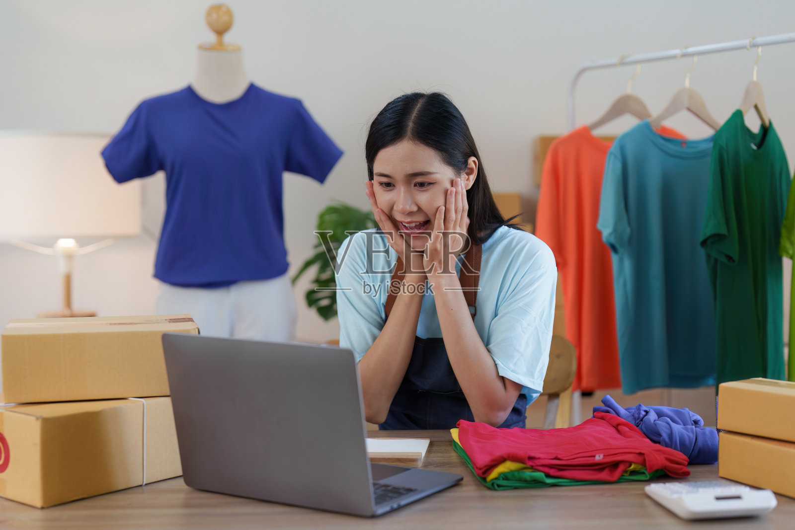 亚洲女性时装设计师布裁缝创意工作的新系列。快乐的网上商店老板准备运输订单照片摄影图片