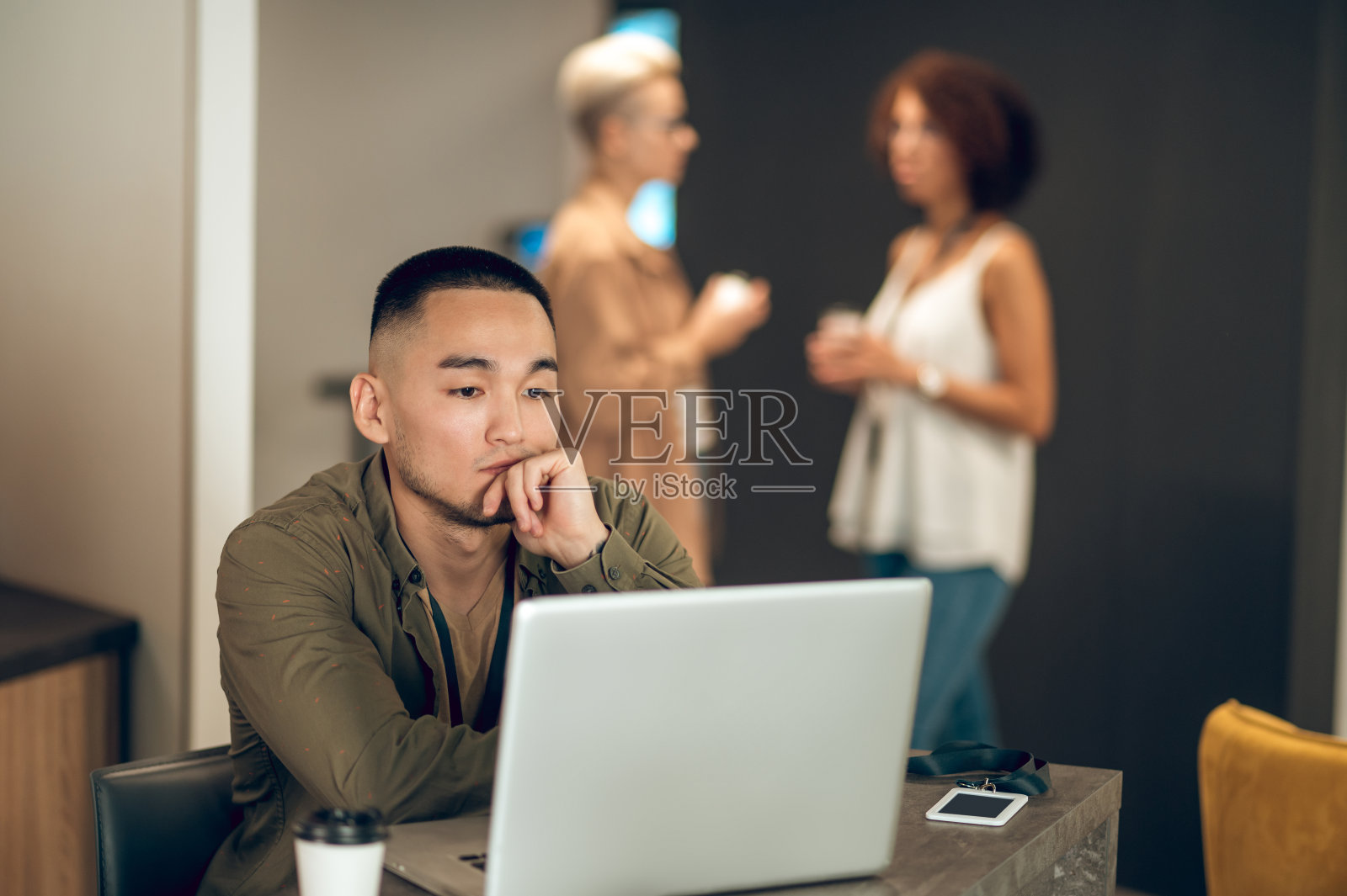 忙碌的年轻办公室经理和他的同事在后台照片摄影图片