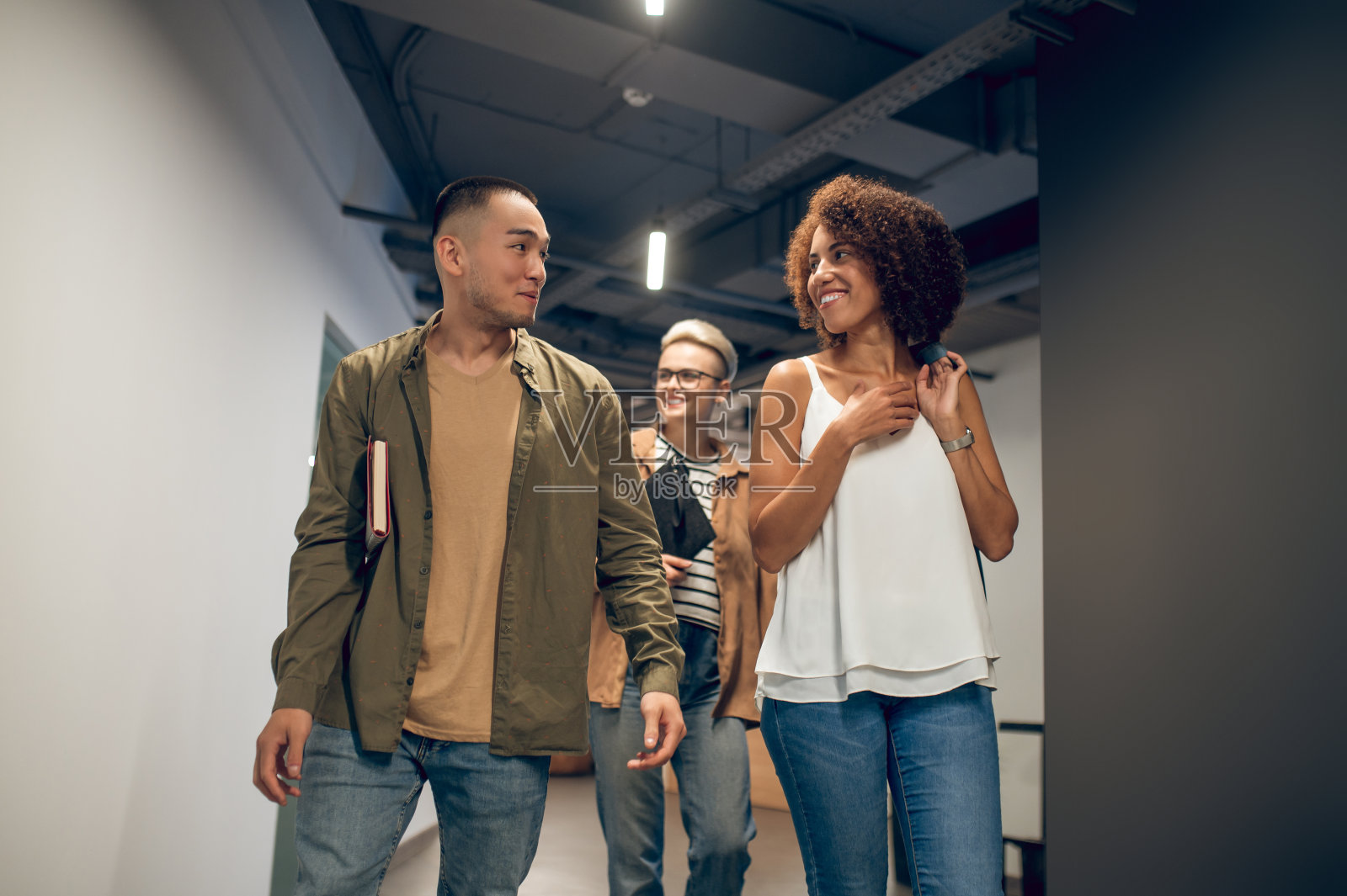 一位开朗的公司员工在走廊上和同事调情照片摄影图片