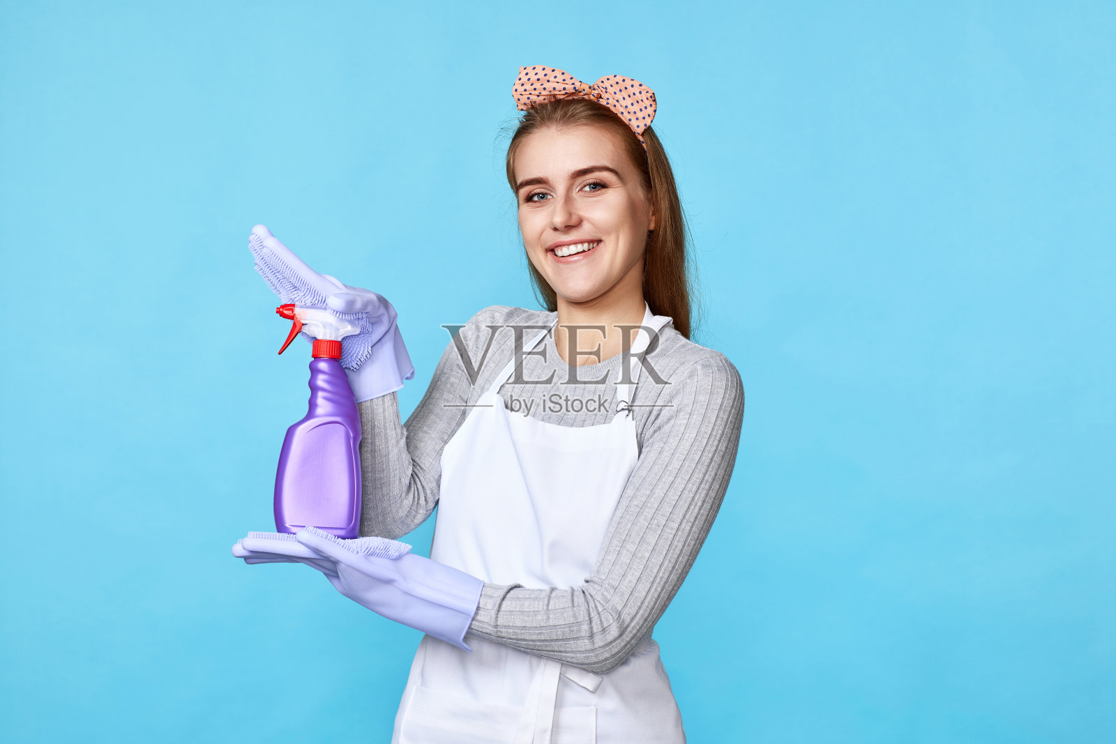 女人戴着橡胶手套拿着清洁剂喷雾器照片摄影图片