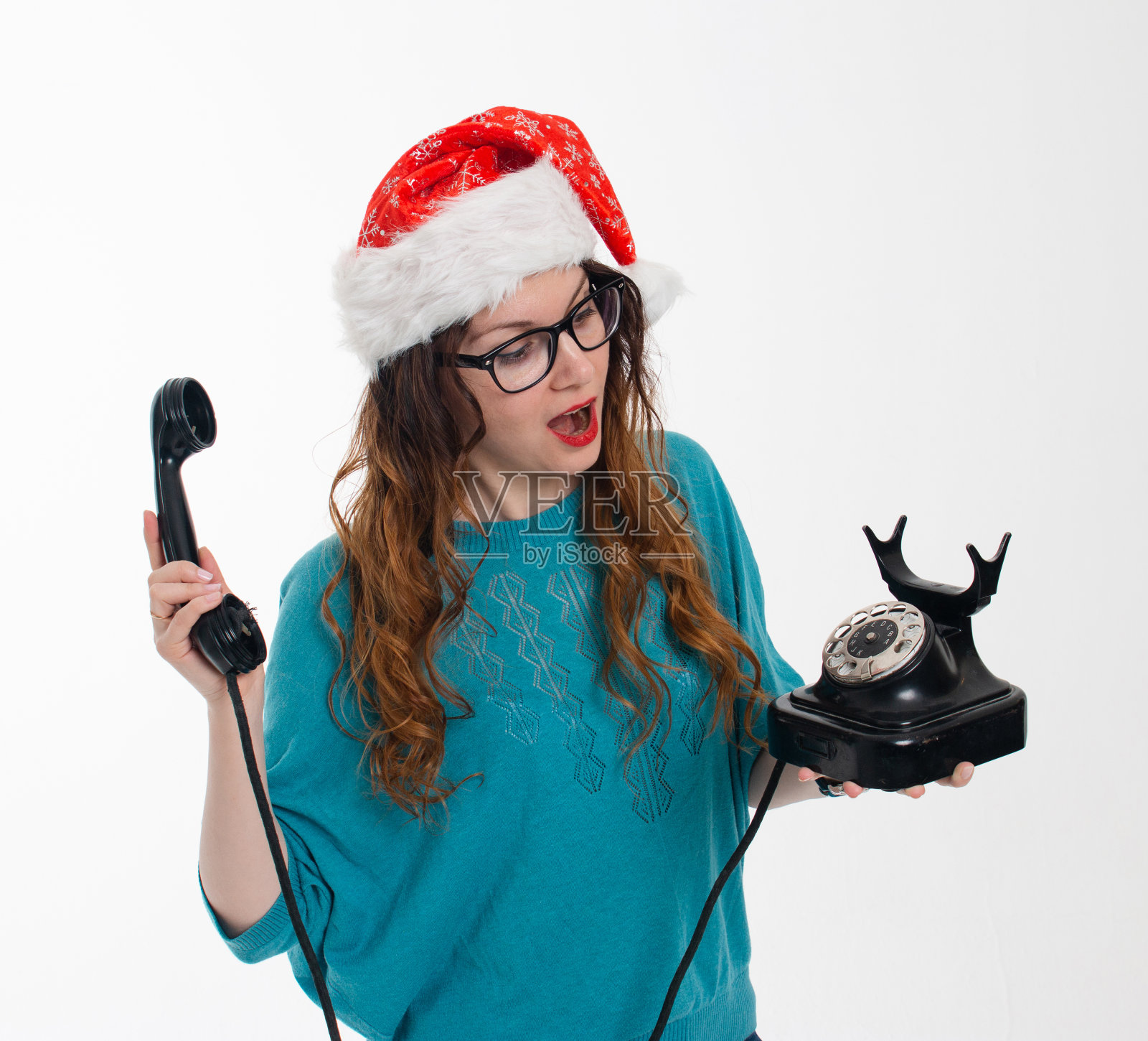 漂亮的女孩在圣诞老人的帽子和旧手机在白色背景照片摄影图片