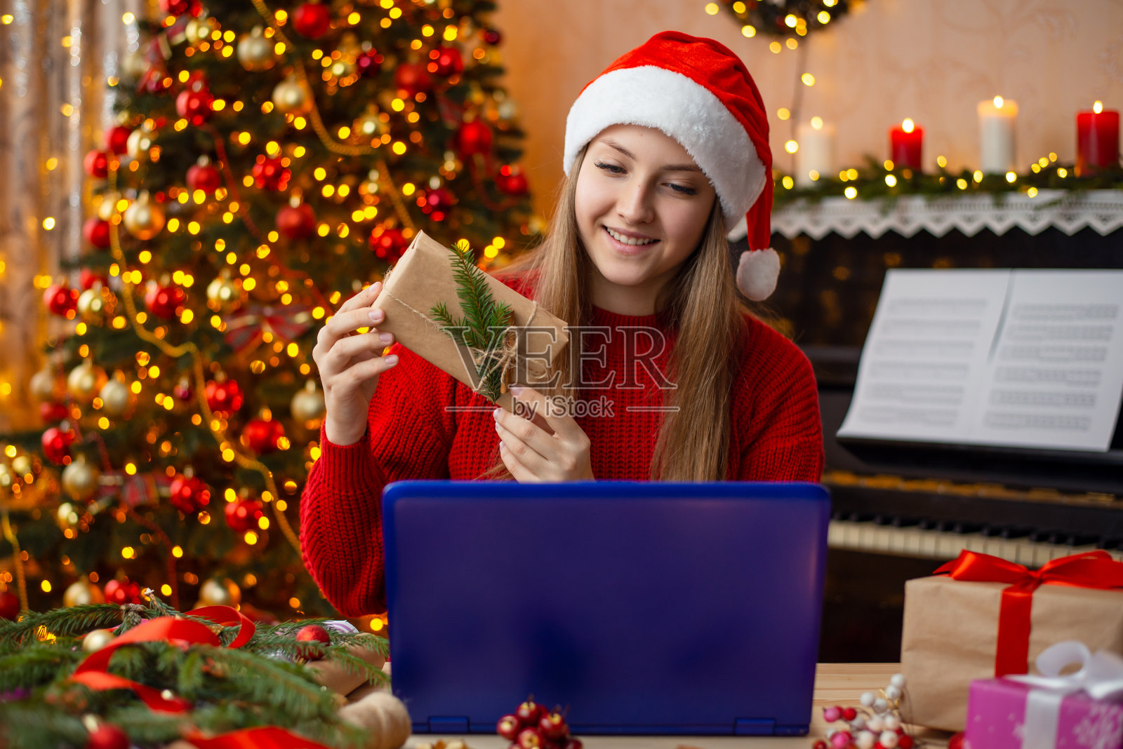 年轻微笑的金发女孩通过互联网与朋友交流，向他展示了一份礼物照片摄影图片