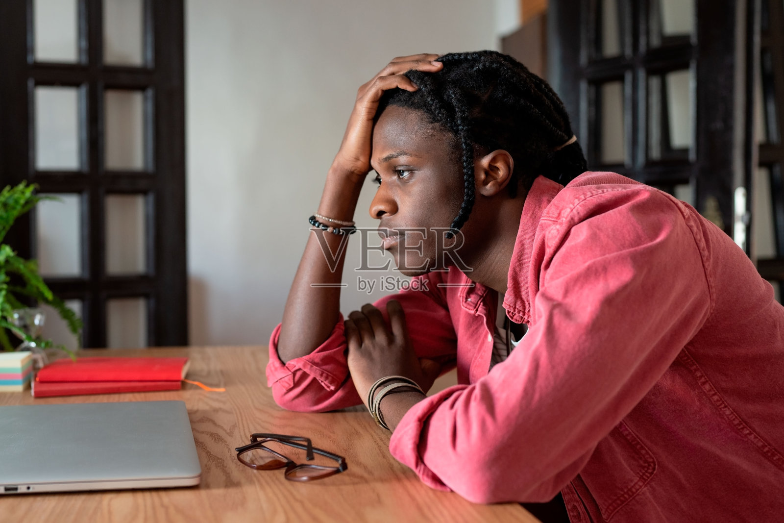 情绪低落的年轻非洲裔男子远程工作者在办公桌前用笔记本电脑应对自由职业倦怠照片摄影图片