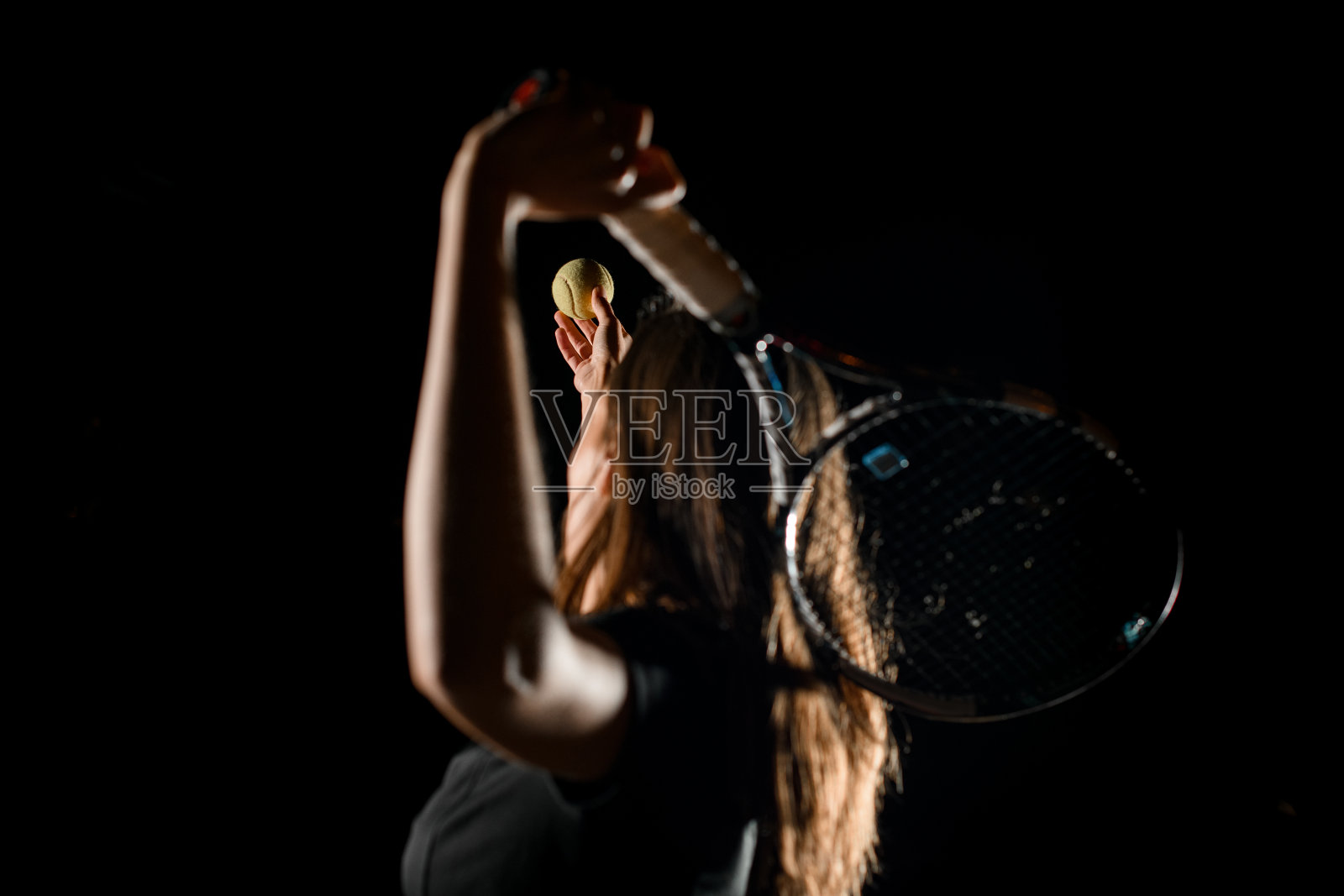 选择性地把注意力集中在女子手中的网球上，女子挥舞球拍击球照片摄影图片