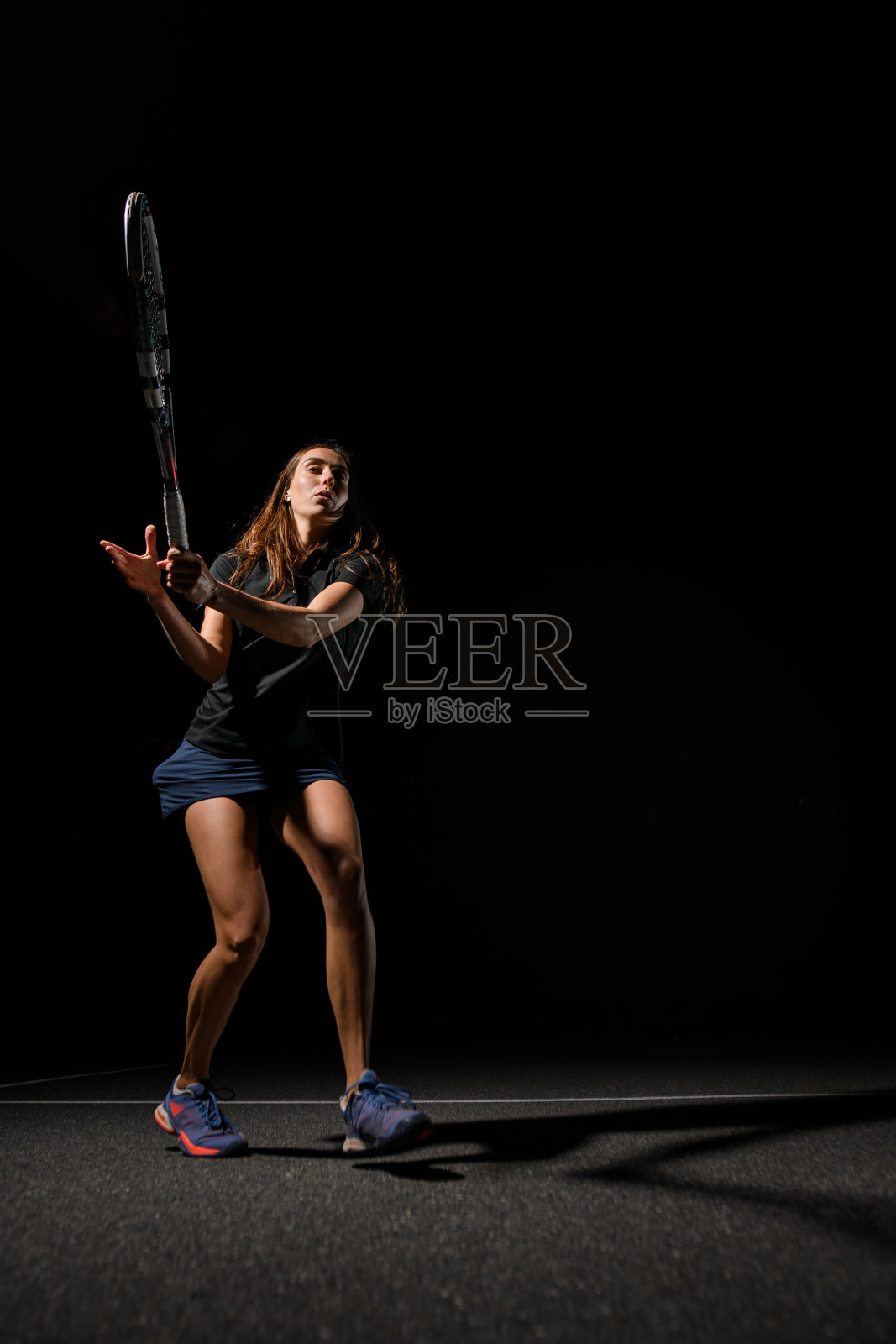 健康的女子拿着网球拍等着打网球。照片摄影图片