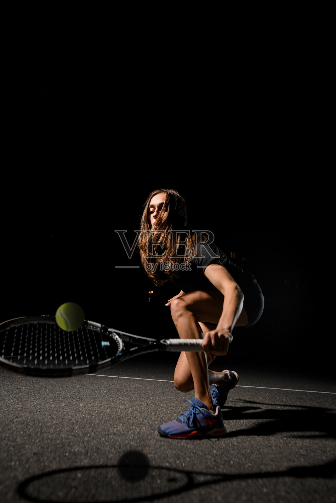 女网球运动员手持网球拍，将黄色网球抛起。照片摄影图片