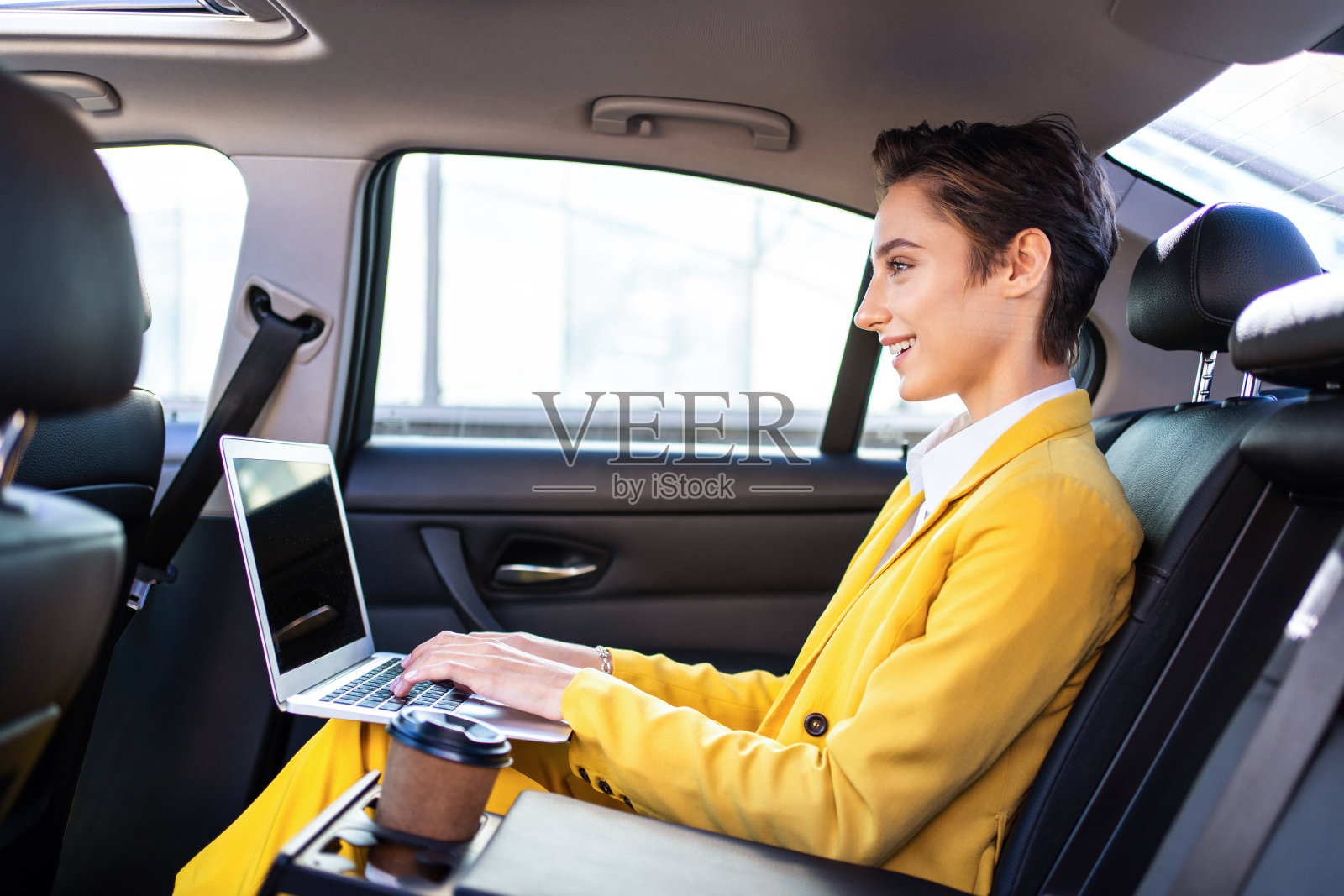 年轻漂亮的短发女子在城市里开车照片摄影图片