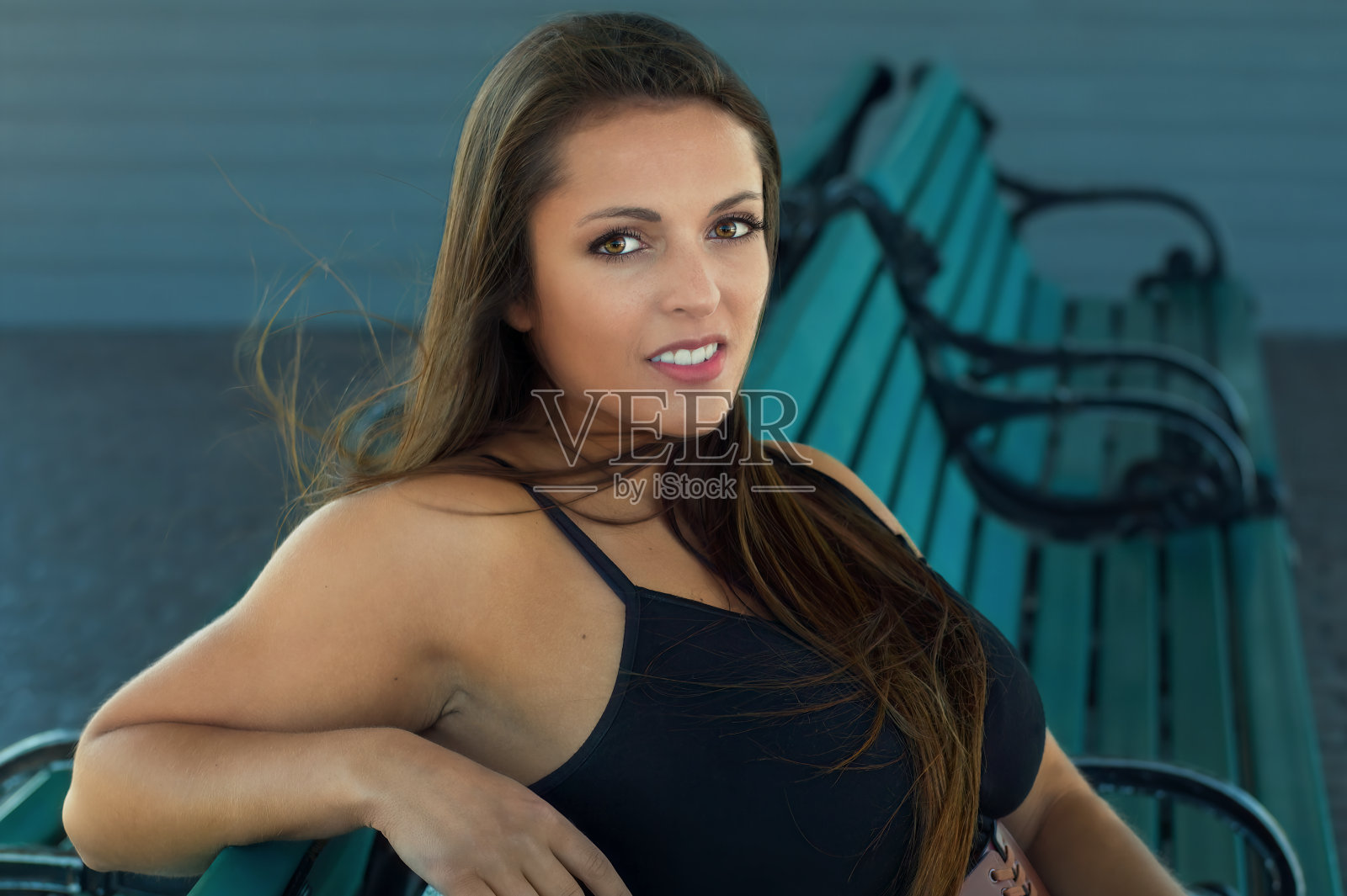 年轻女子坐在长椅上公园长发女士优雅女人的人照片摄影图片