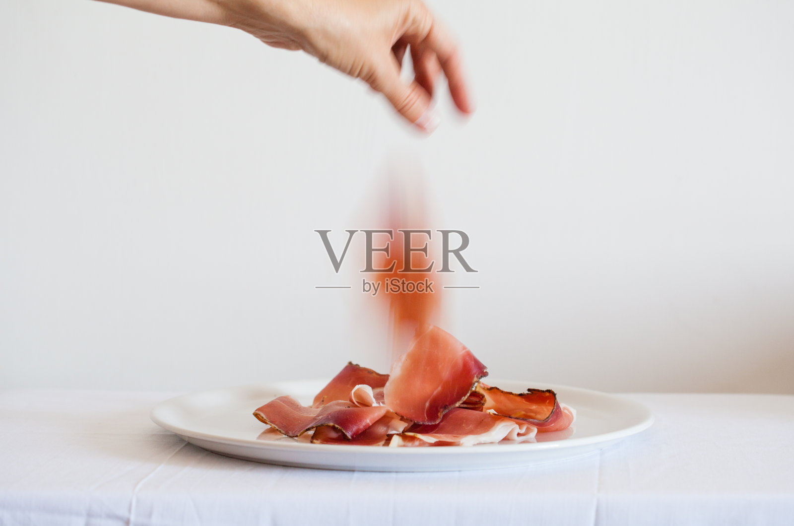 手从盘子里拿火腿，意大利照片摄影图片