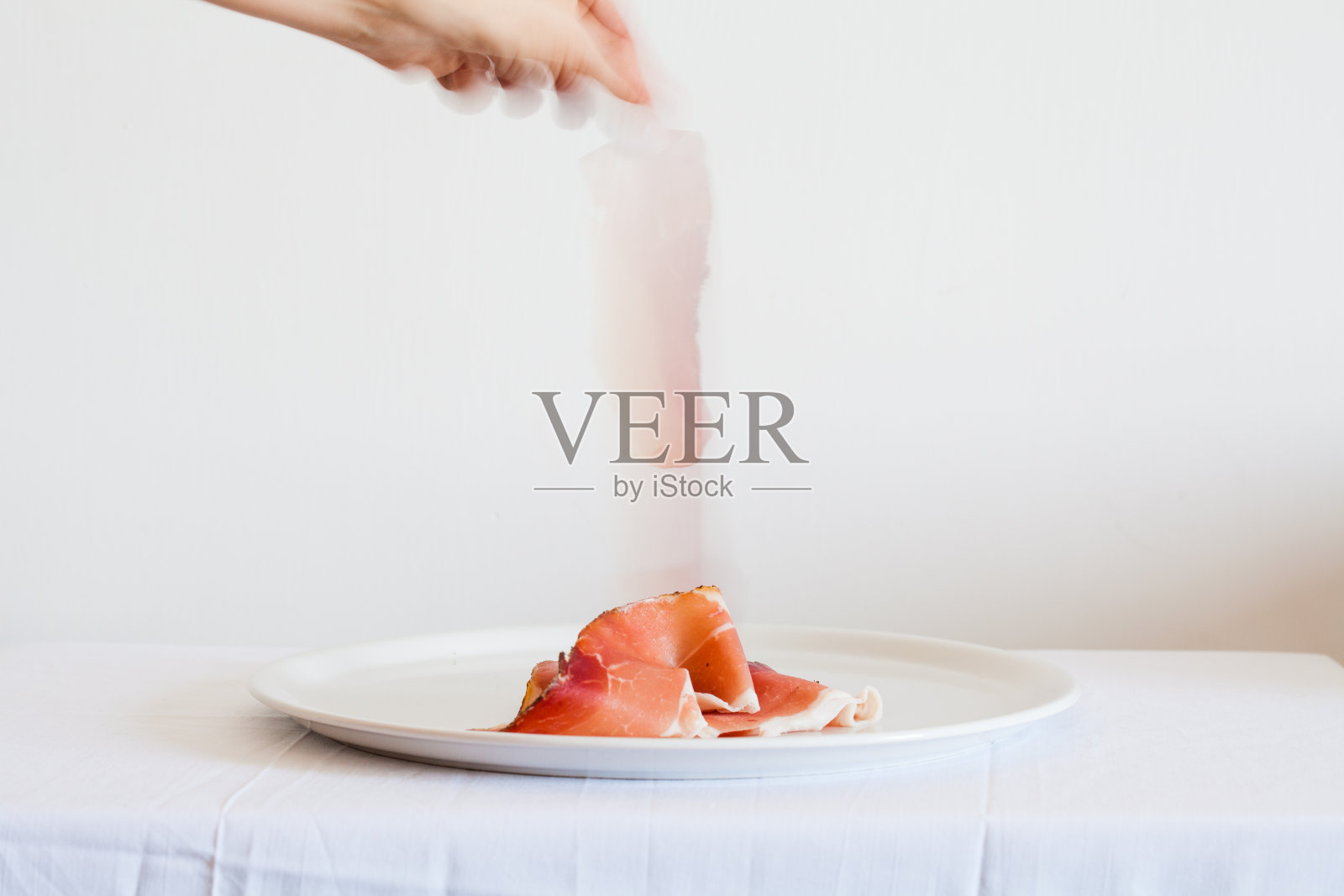 手从盘子里拿火腿，意大利照片摄影图片