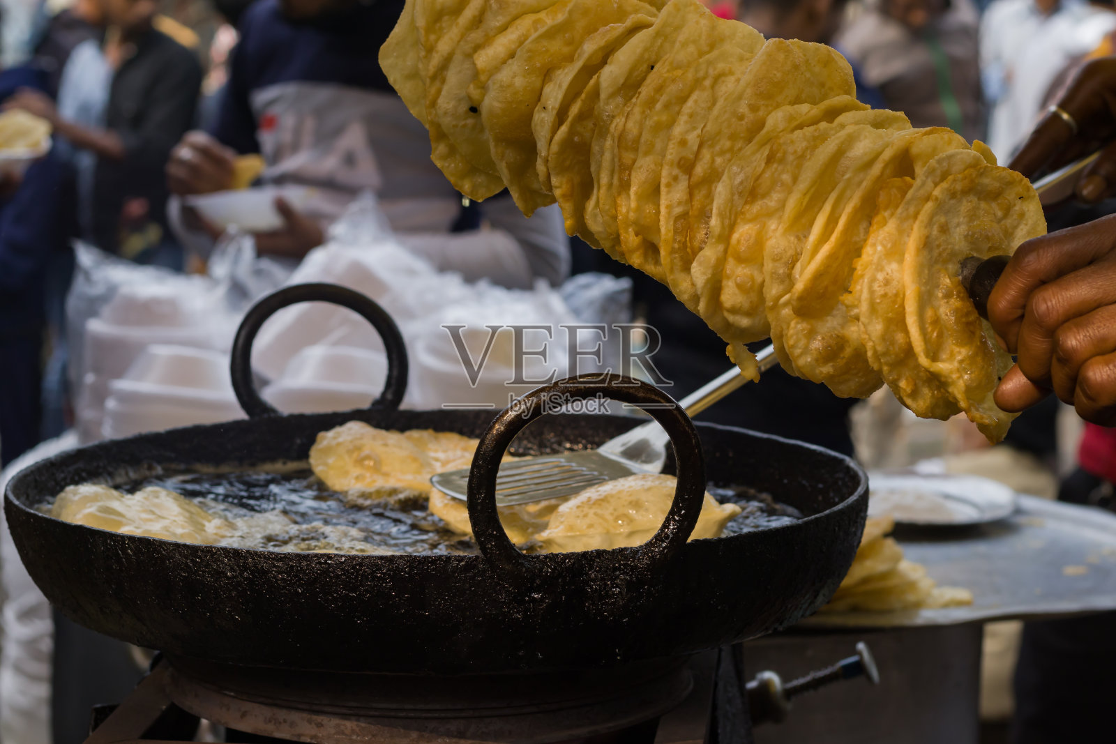 Poori或者puri或者luchi在热气腾腾的油里炸。传统的印度早餐小吃。照片摄影图片