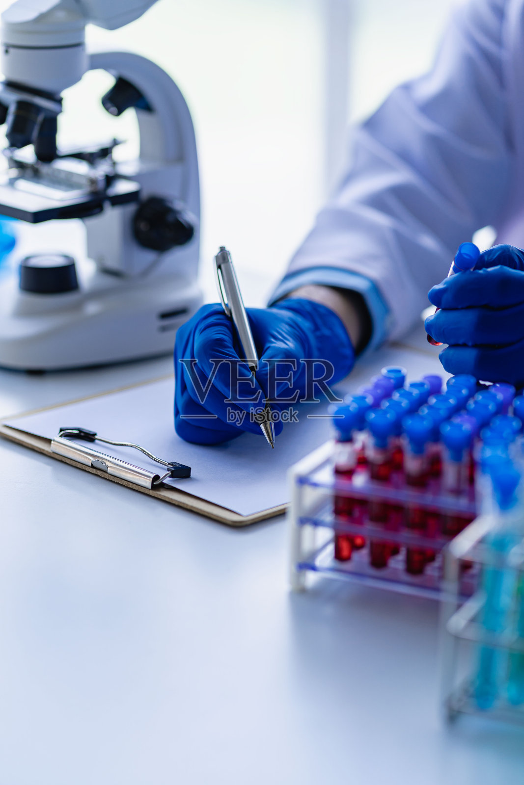 专业的医生检查动脉血样，专业的护士用显微镜研究，实验室办公室女实验室助理拿着血液试管特写照片摄影图片