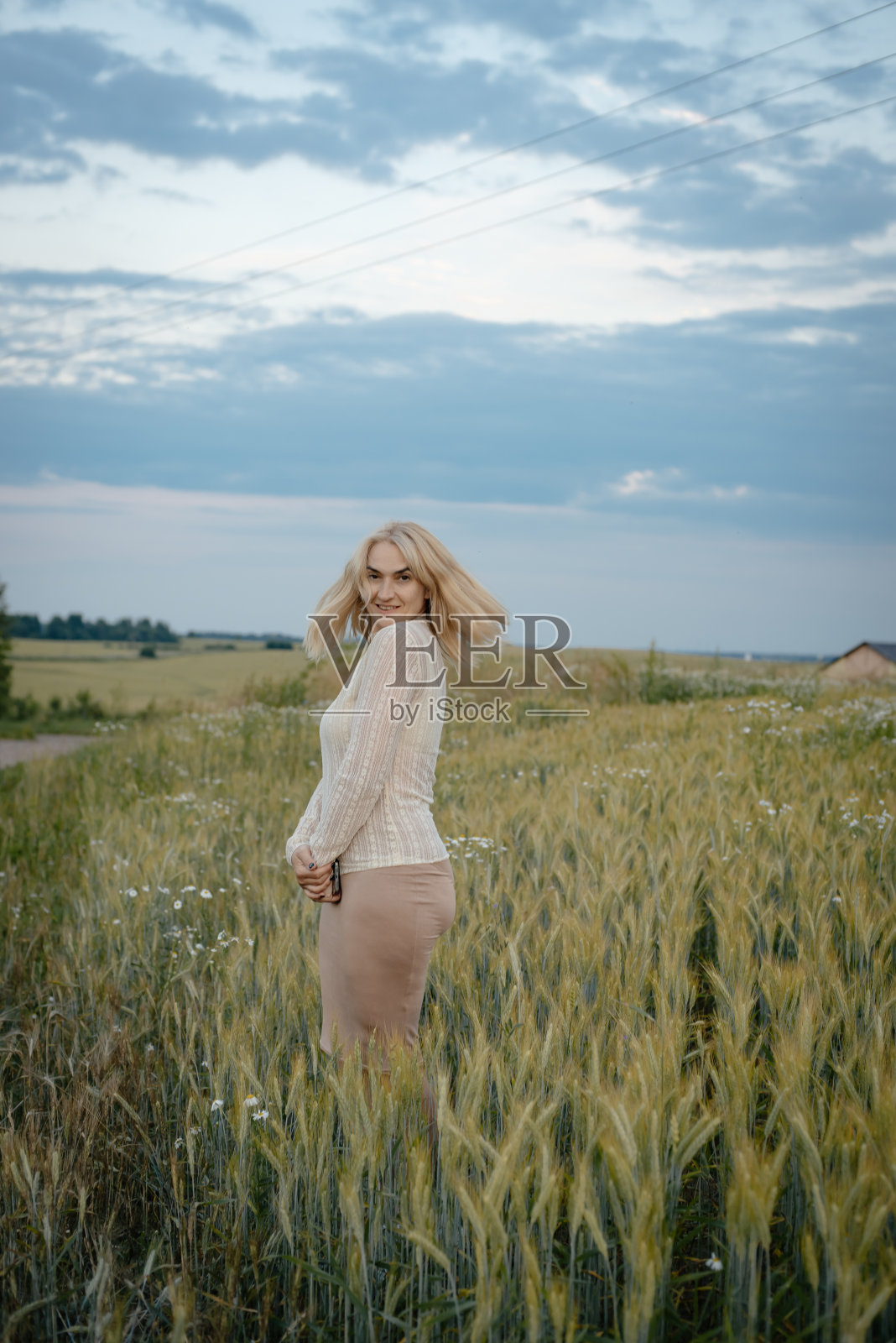 一个女孩在球场上。日落时的壮观照片。一个女人走在田野里照片摄影图片