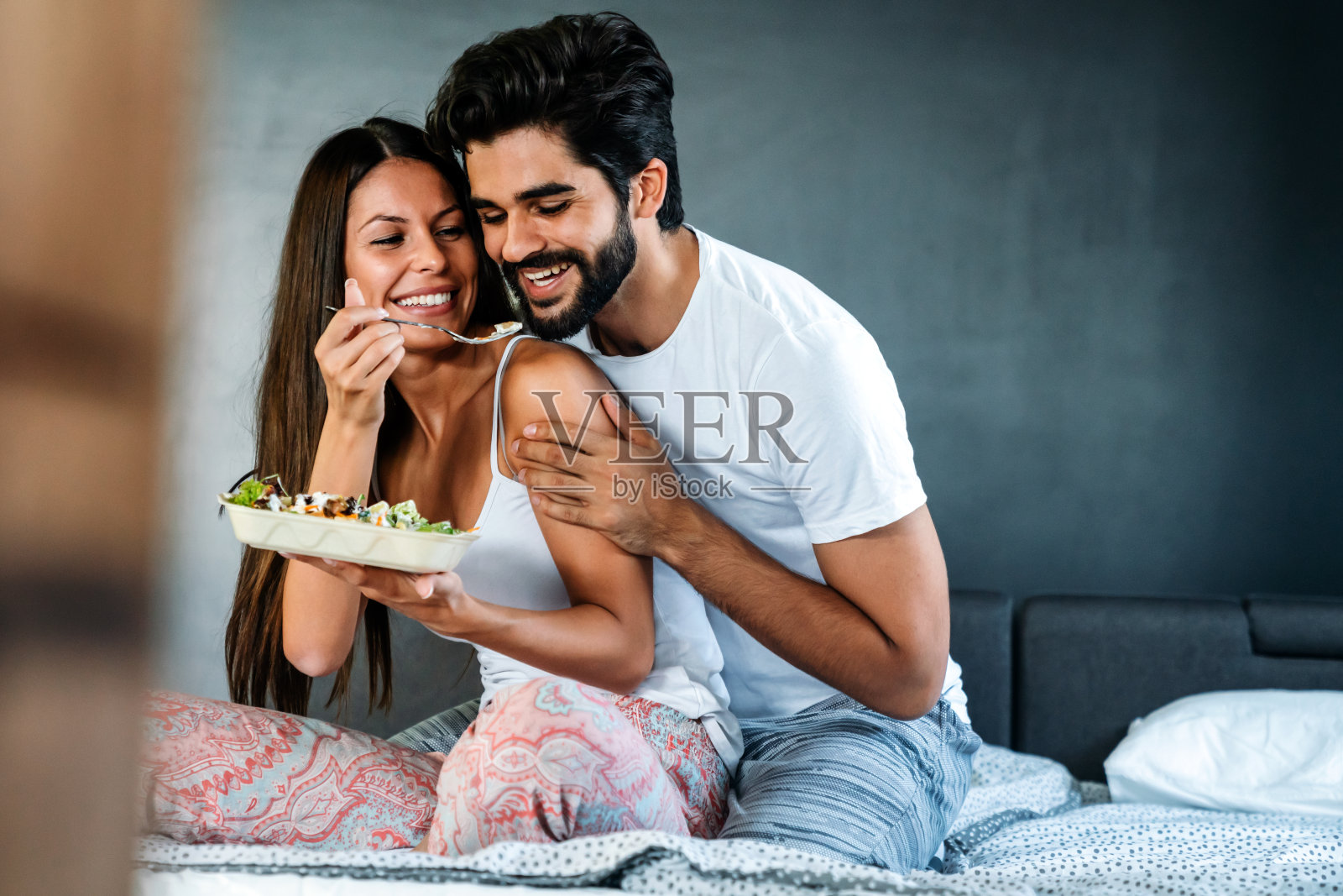 热恋中的情侣在床上吃早餐。人、爱、食的概念。照片摄影图片