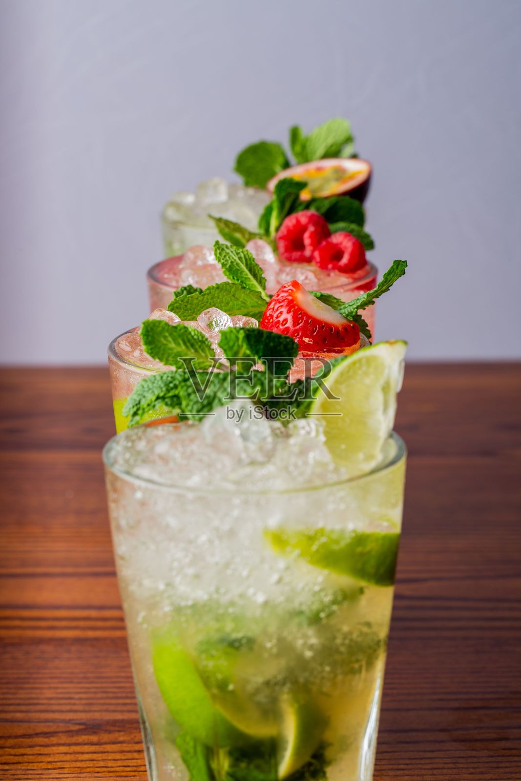 垂直拍摄一些柠檬水放在一排桌子上。照片摄影图片